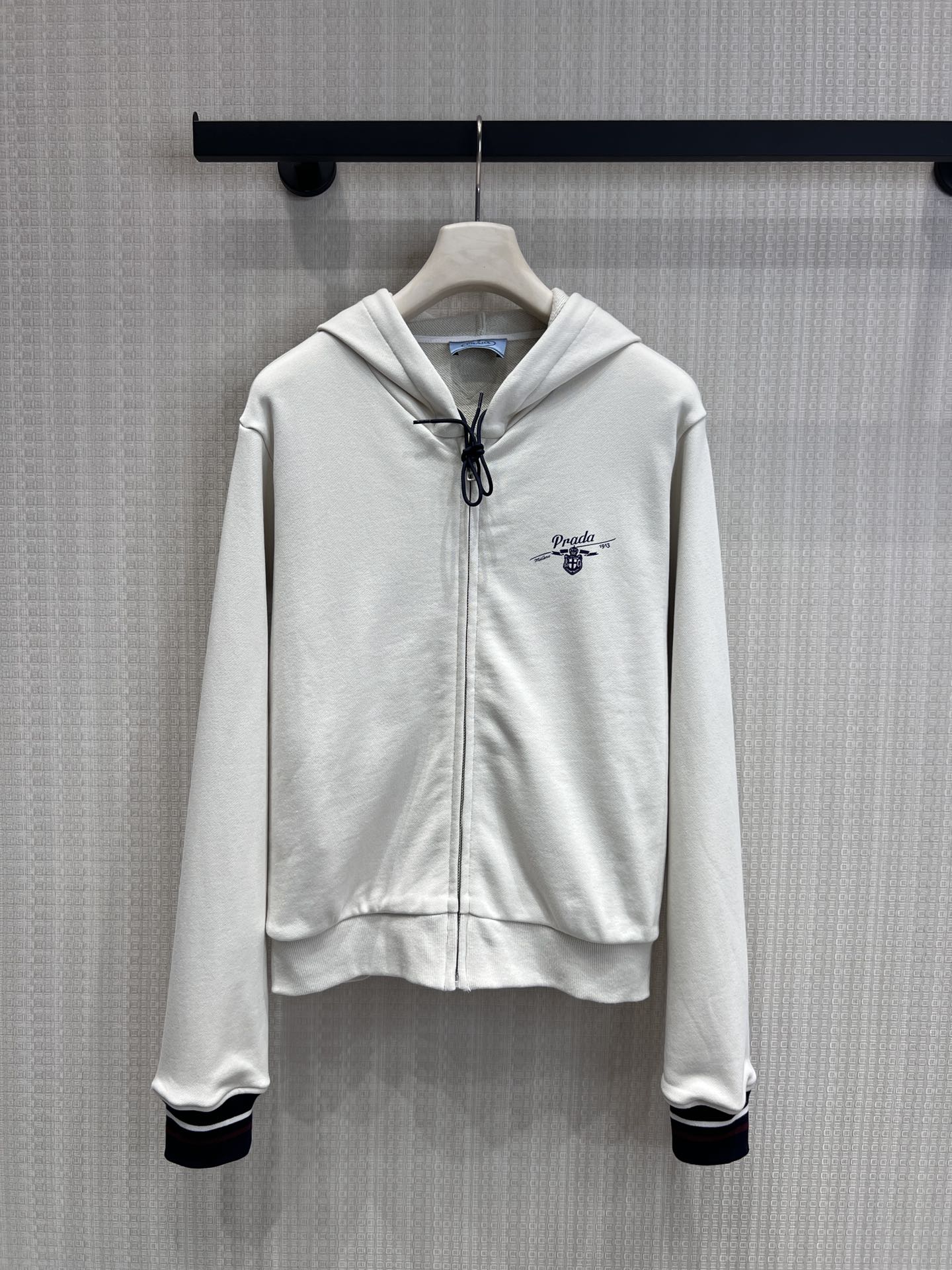NO:762202,Support for exchange Pra* 25Ss early spring new style college style letter print zipper hooded sweatshirt jacket丨Exclusively developed by yb!  Top quality production!  Perfect the balance between laziness and sophistication!  The off-white tone is gentle and versatile, and the soft cotton fabric is skin-friendly and breathable. The classic hooded design is equipped with a full zipper closure, which can be easily put on and taken off and can create a casual look with a half-open collar. The contrasting stripes on the cuffs echo the exquisite letter printing on the body, instantly giving a college-style atmosphere, and the short silhouette can also optimize the body ratio.  For example, pairing with a pleated skirt is exclusive to sweet girls. Pairing it with wide-leg pants can unlock a cool street feel. One piece can cover the fashion of all casual styles ~ ready-made S/M/L real-shot detailed pictures, prada, hoodie, sweatshirts, skirts, jackets  & coats,hats,19860909支持换款Pra* 25Ss早春新款 学院风字母印花拉链连帽卫衣外套丨独家yb开发！顶级高版出品！把慵懒与精致的平衡玩到极致！米白色调温柔又百搭,软糯的棉质面料亲肤又透气,经典连帽设计搭配全拉链开合,穿脱自如还能打造半开领的随性造型；袖口撞色条纹与衣身精致的字母印花相呼应,瞬间拉满学院风氛围,短款廓形还能优化身材比例.搭百褶裙是甜妹专属,配阔腿裤又能解锁酷飒街头感,一件承包所有休闲造型的时髦度～现货发售S/M/L实拍细节图,,prada,hoodie,sweatshirts,skirts,jackets & coats,hats,,Women's clothing