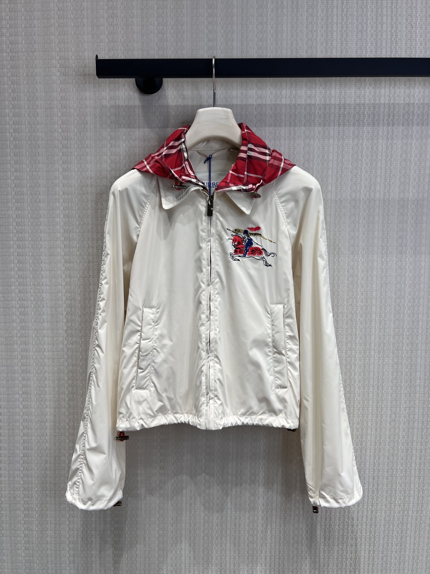 NO:762701,Support exchange Bur* 26Ss early spring New Year's Eve series hooded short jacket丨exclusively developed by yb!  High quality production!  The off-white base carries British genes. The iconic war horse embroidery appears on the left chest. The red and black plaid hooded lining hides classic details. The drawstring hem and elastic cuffs neatly outline the body shape. The lightweight windproof fabric is flexible and practical in spring, whether it is paired with the same style.  Whether it is a sweater or a denim item, it can be switched freely between daily life and occasions. It is the finishing touch of the new year's wardrobe that has both a sense of ritual and practicality. Ready-made S/M/L real shot details, burberry, jackets  & coats,hats,19860909支持换款Bur* 26Ss早春新禧贺岁系列 连帽短款外套丨独家yb开发！高版出品！以米白基底承载英伦基因.标志性战马刺绣跃于左胸,红黑格纹连帽内衬暗藏经典细节,抽绳收摆与松紧袖口利落勾勒身形.轻量防风面料兼顾春日灵动与实用,无论是搭配同系列针织衫还是牛仔单品,都能在日常与场合间自如切换,是新岁衣橱里兼具仪式感与实穿性的点睛之笔.现货发售S/M/L实拍细节图,,burberry,jackets & coats,hats,,Women's clothing