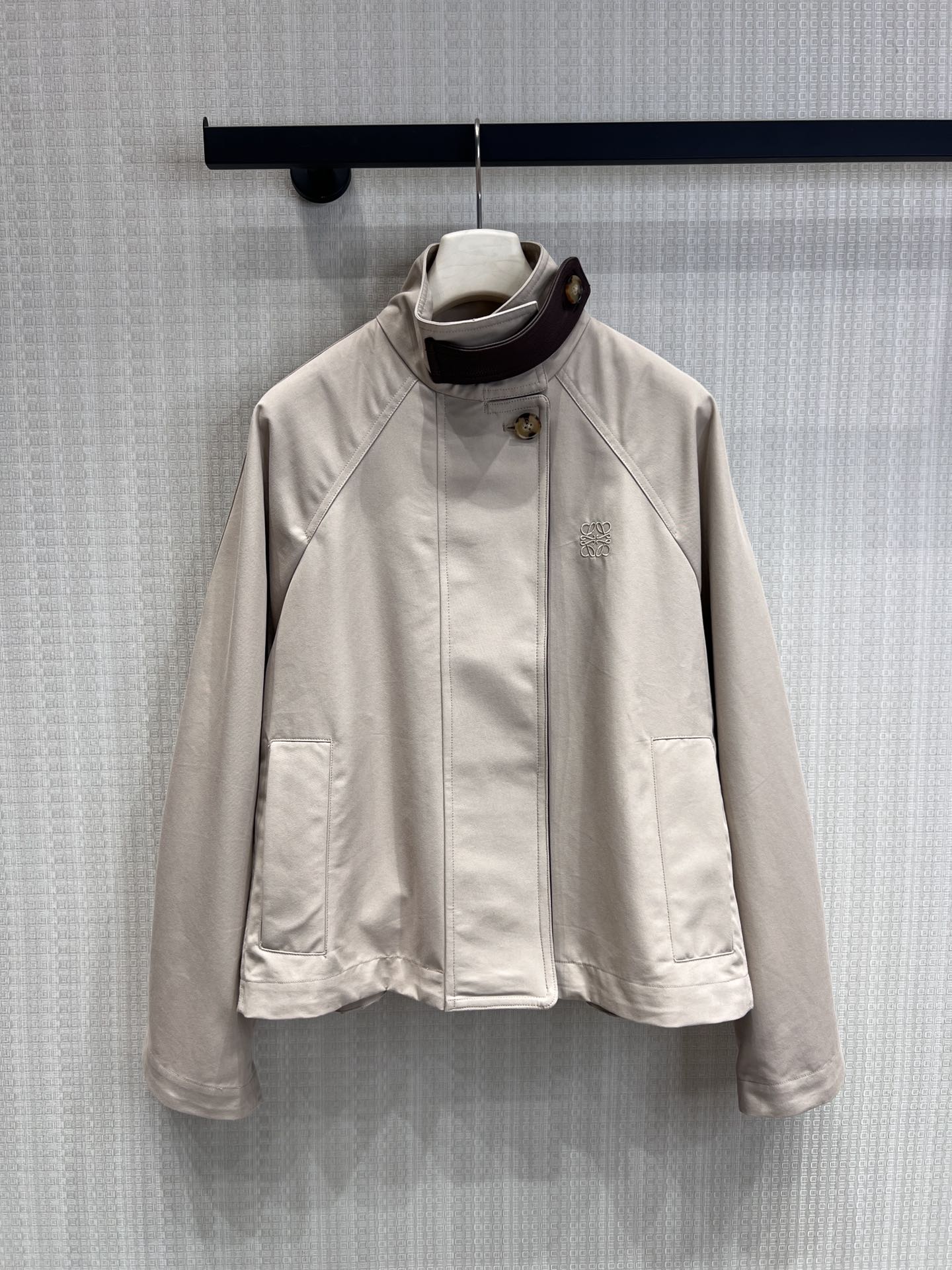 NO:762694,Supports replacement of Loe* 26Ss early spring new style logo embroidered short windbreaker jacket丨exclusively developed by yb!  Top quality production!  Made of light khaki high-density cotton fabric, it has both a crisp texture and a soft drape. The stand-up collar is spliced with dark brown leather details and embellished with retro round buttons, echoing the ingenuity. The Anagram logo is low-key embossed on the left side of the body, and the shawl-style structure and drop sleeves are on the back.  The shape gives the loose silhouette a layered aesthetic. The ribbed cuffs and hidden zipper design take into account windproof practicality and minimalist aesthetics. It is a highly suitable item for spring commuting and city roaming. Ready-made S/M/L real shot details,,loewe,jackets  & coats,shawls,19860909支持换款Loe* 26Ss早春新款 徽标刺绣短款风衣外套丨独家yb开发！顶级高版出品！以浅卡其色高密棉质面料打造,兼具挺括质感与柔和垂坠感.立领处拼接深棕色皮革细节,点缀复古圆形纽扣,呼应匠心底蕴.衣身左侧低调压印Anagram徽标,后背的披肩式结构与落肩袖型,赋予宽松廓形以层次美感.罗纹袖口与隐藏式拉链设计,兼顾防风实用性与极简美学,是春日通勤与城市漫游的高适配单品.现货发售S/M/L实拍细节图,,loewe,jackets & coats,shawls,,Women's clothing