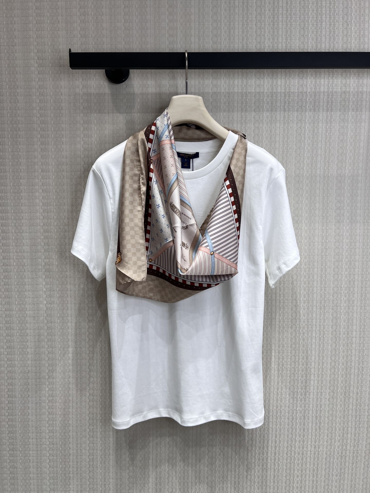 NO:803016,Louis Vuitt**26 spring and summer new style wears classic silk scarves on the body. It is inspired by the classic silk scarves engraved in the bones and integrates the aesthetic genes of the century-old brand into daily wear.  High-gram heavyweight cotton material is selected, which is skin-friendly and breathable, crisp and stylish, and has a high-end sense of relaxation on the upper body; the front piece is spliced with silk satin printing, which restores the retro texture and exquisite details of the silk scarf. The checkerboard pattern, retro coat of arms, and contrasting edges are all replicas of the classic elements of the luxury brand, showing nobility in a low-key manner. Ready-made smL real shot details, Louis Vuitton, real silk,19860909Louis Vuitt**26春夏新款把经典丝巾穿在身上,是刻在骨子里的经典丝巾为灵感,将百年品牌的美学基因融入日常穿搭. 甄选高克重重磅棉料,亲肤透气,挺括有型,上身自带高级松弛感；前片拼接真丝缎面印花,还原丝巾的复古肌理与精致细节,棋盘格、复古纹章、撞色镶边,每一处都复刻了奢牌的经典元素,低调中尽显贵气.现货出售smL实拍细节图,,louis vuitton,real silk,,Women's clothing