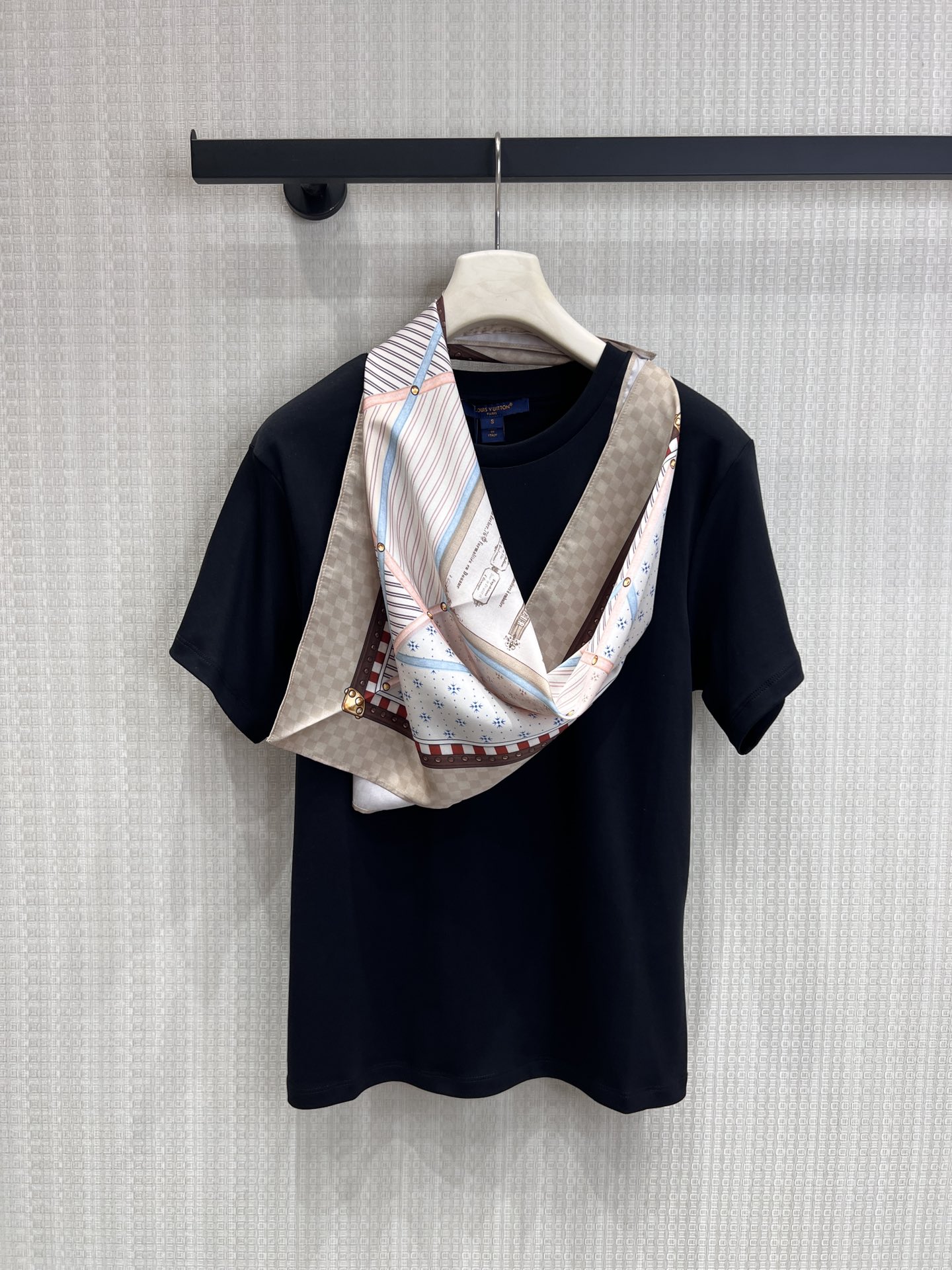 NO:803019,Louis Vuitt**26 spring and summer new style wears classic silk scarves on the body. It is inspired by the classic silk scarves engraved in the bones and integrates the aesthetic genes of the century-old brand into daily wear.  High-gram heavyweight cotton material is selected, which is skin-friendly and breathable, crisp and stylish, and has a high-end sense of relaxation on the upper body; the front piece is spliced with silk satin printing, which restores the retro texture and exquisite details of the silk scarf. The checkerboard pattern, retro coat of arms, and contrasting edges are all replicas of the classic elements of luxury brands, showing nobility in a low-key manner. Ready for sale sml real shot details, Louis Vuitton, real silk,19860909Louis Vuitt**26春夏新款把经典丝巾穿在身上,是刻在骨子里的经典丝巾为灵感,将百年品牌的美学基因融入日常穿搭. 甄选高克重重磅棉料,亲肤透气,挺括有型,上身自带高级松弛感；前片拼接真丝缎面印花,还原丝巾的复古肌理与精致细节,棋盘格、复古纹章、撞色镶边,每一处都复刻了奢牌的经典元素,低调中尽显贵气.现货出售smL 实拍细节图,,louis vuitton,real silk,,Women's clothing