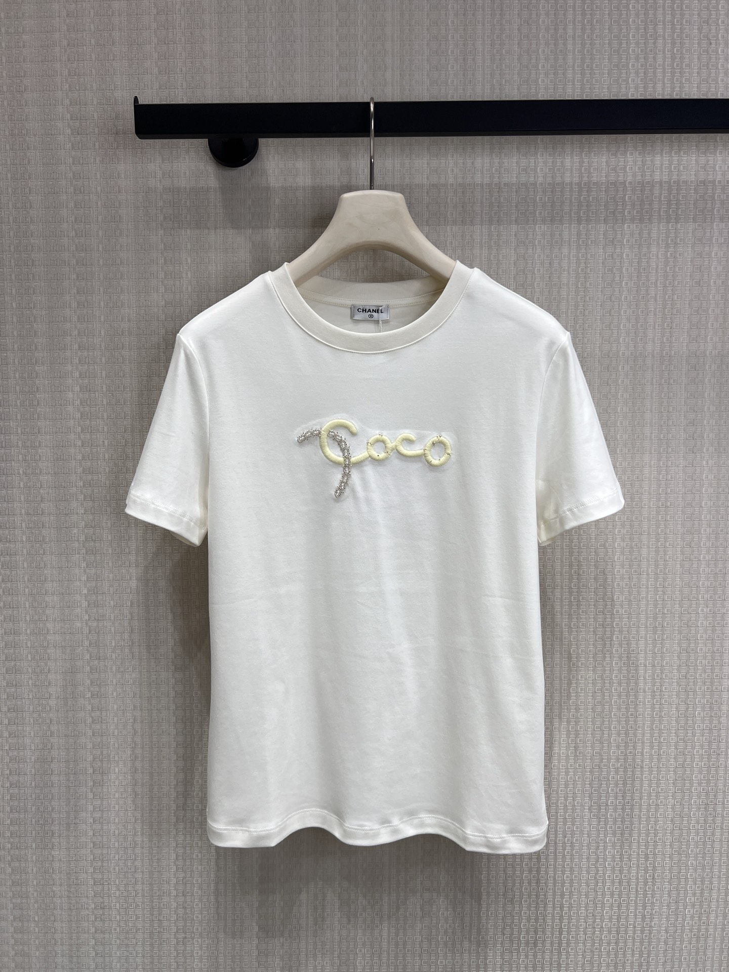 NO:834951,The new spring and summer 26 Coco letter embroidery high-count cotton T-shirt is made of high-count cotton fabric, which is soft and skin-friendly, has a soft drape feeling, and is not easy to deform after long-term wear. The Coco letters on the chest are made of hand-beading and contrasting stitching technology. Every detail shows the exquisite texture, and is low-key and high-end.  The basic round neck + straight short-sleeved version modifies the shoulder and neck lines, regardless of body shape or style. The black and white colors are suitable for all combinations. It is an indispensable universal item in the spring and summer wardrobe. Ready for sale sml,, T-shirt, tees, t-shirt,1986090926春夏新品Coco字母刺绣 高支棉T恤 甄选高支棉面料,触感柔软亲肤,自带柔和垂坠感,久穿不易变形. 胸前Coco字母采用手工钉珠与撞色缝线工艺,每一处细节都彰显精致质感,低调中透着高级. 基础圆领+直筒短袖版型,修饰肩颈线条,不挑身材不挑风格,黑白两色适配所有搭配,是春夏衣柜里不可或缺的万能单品.现货出售 smL,,T-shirt,tees，t-shirt,,Women's clothing