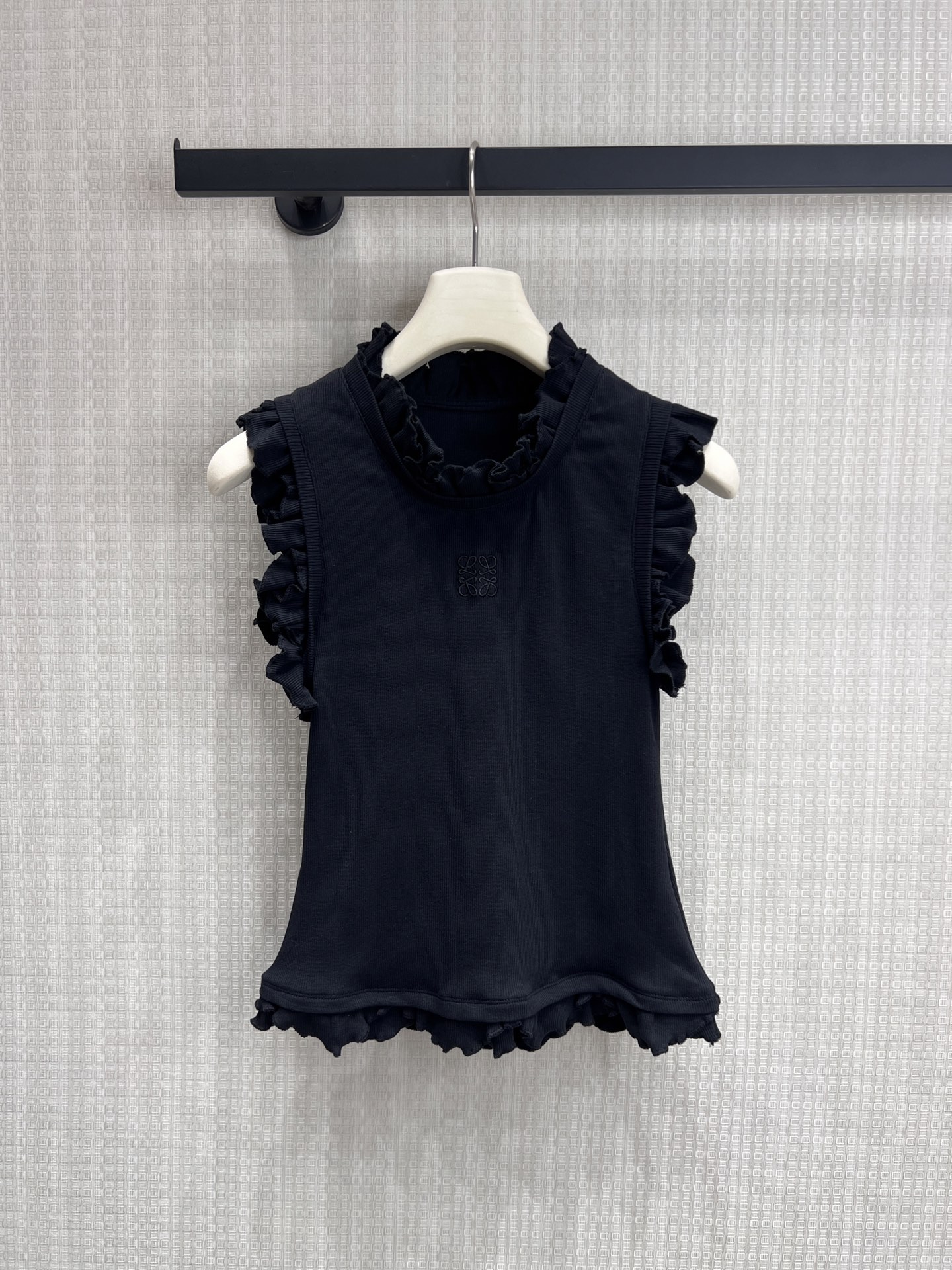NO:835617,New product for spring and summer 2026 Loe** ruffle vest is made of high-elastic soft and waxy knitted fabric. It is skin-friendly, breathable and not stuffy. It has a soft matte texture. It has excellent elasticity, fits the upper body without tightness, and is not easily deformed after long-term wear. It has a waist-slim fit, neat tailoring outlines the waistline, optimizes body proportions, and can easily wear a small waist. The high collar + ruffle design modifies the neckline, and has a right-angled shoulder effect, making it look slimmer and more elegant. Ready for sale  smL,,loewe,1986090926春夏新品 Loe**荷叶边背心高弹软糯针织面料,亲肤透气不闷汗,自带柔和哑光质感,弹力优秀,上身贴合不紧绷,久穿不易变形. 收腰修身版型,利落剪裁勾勒腰线,优化身材比例,轻松穿出小蛮腰；高领+荷叶边设计修饰颈线,自带直角肩效果,显瘦又显气质.现货出售 smL,,loewe,,Women's clothing