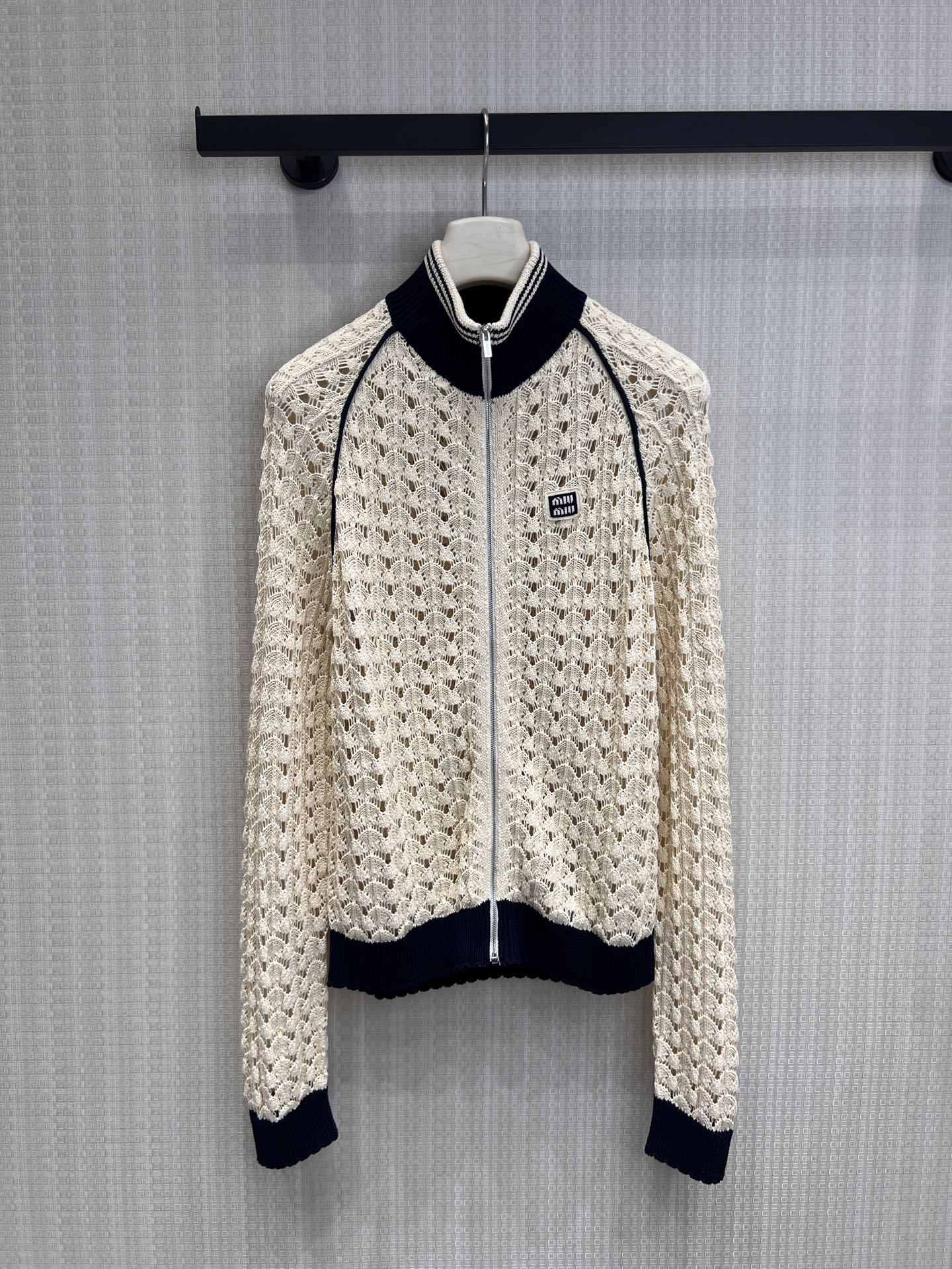 NO:840141,26 spring and summer new products Mi** series plutocratic style hollow knitted cardigan, apricot beige × navy blue contrasting colors, replica of classic college sports lines, handmade crochet hollow weaving, breathable and light with hazy soft light, small logo embroidery + stand-up collar zipper design, full of retro and sophistication with one click, gentle and dignified when worn alone, creating a relaxed feeling when layered, unlocking all matching scenes in spring and summer. Ready for sale smL,,1986090926春夏新品 Mi**系财阀千金风镂空针织开衫 奶杏米白×藏青撞色,复刻经典学院运动线条,手工感钩花镂空织法,透气轻盈自带朦胧柔光,小标刺绣+立领拉链设计,复古与精致感一键拉满, 单穿温柔显贵,叠穿打造松弛感,解锁春夏所有搭配场景.现货出售smL,,,Women's clothing