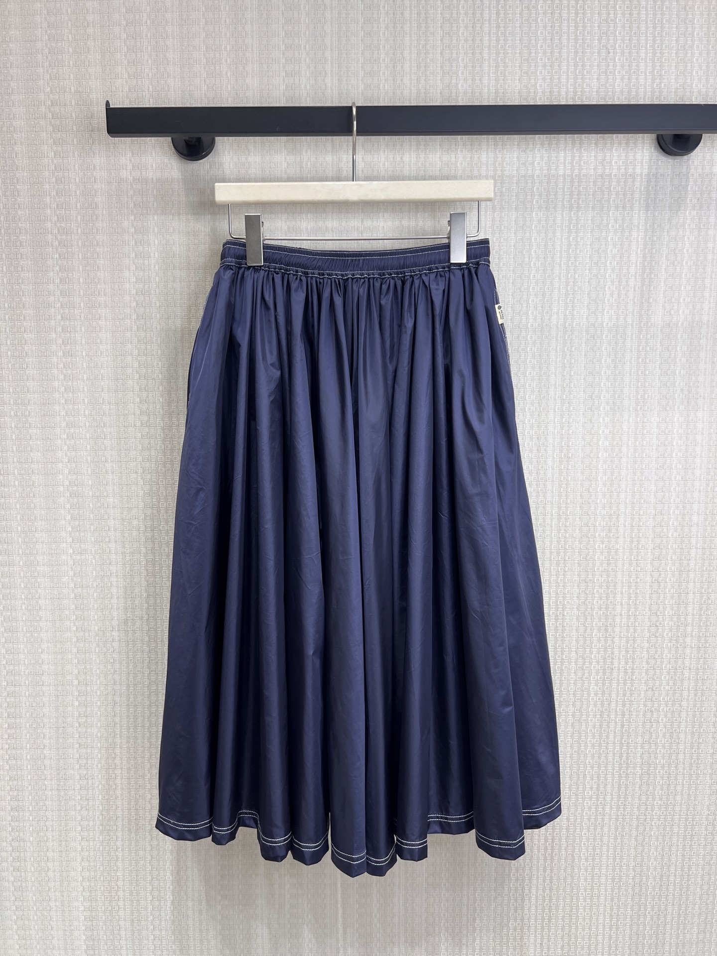 NO:840200,26 spring and summer new product Pra** navy blue topstitch mid-length skirt with minimalist aesthetics, made of navy blue matte fabric, with contrasting topstitch to outline the skirt outline, elastic waistband for comfort and fit. The loose A-line version has a full drape, hides the body and looks slim while having a retro college atmosphere. It can be matched with the same series of jackets, or can be used alone to create a relaxed commuting style, easily unlocking Italian elegance. Ready for sale smL, prada, skirts, jackets &  coats,1986090926春夏新品 Pra**藏青明线中长半身裙 极简美学,以藏青哑光面料打造,搭配撞色明线勾勒裙摆轮廓,松紧腰头兼顾舒适与贴合度.宽松A字版型垂坠感十足,藏肉显瘦的同时自带复古学院氛围,与同系列外套可搭配成套,也可单独打造松弛通勤造型,轻松解锁意式优雅.现货出售smL,,prada,skirts,jackets & coats,,Women's clothing