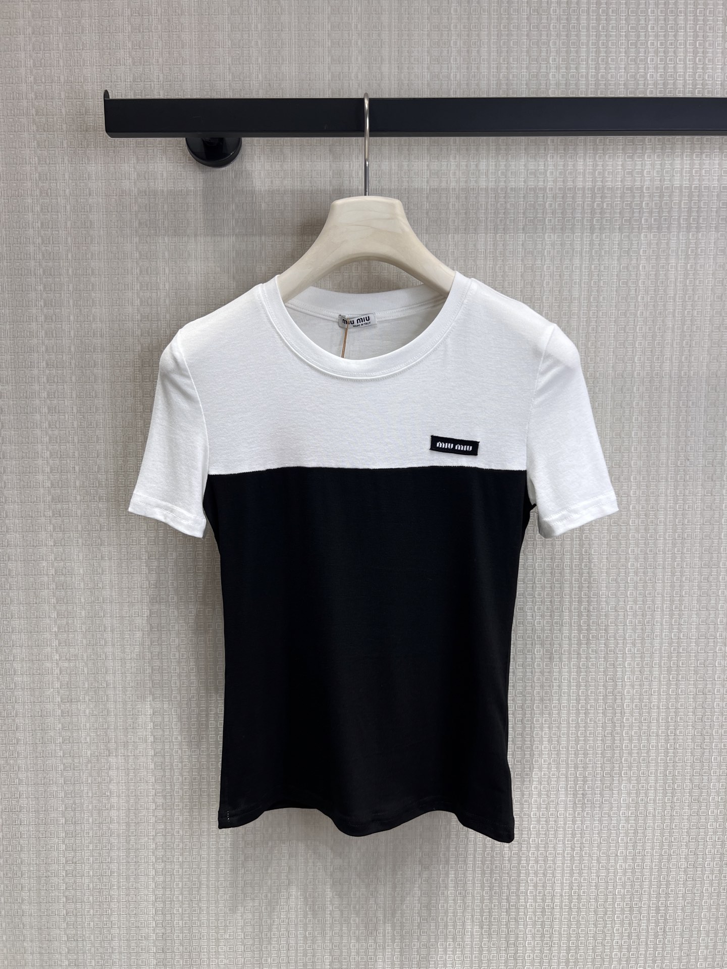 NO:844000,New for spring and summer 26, Miu is a contrasting T-shirt, which balances the sweetness and coolness of the academy just right. The classic white + gray/white + black contrasting design and neat splicing lines weaken the monotony of the basic style. The brand woven logo on the chest is low-key and recognizable, with its own brand halo.  The high-elastic soft cotton fabric is skin-friendly and breathable. The slim-fitting and slightly short version just exposes the waistline. Paired with low-waist jeans, it is the perfect Korean hot girl style. It can be easily used for daily life, commuting, and dating. It is a versatile item in the wardrobe!  Spot sale smL,,miumiu,jeans,1986090926春夏新品 Miu系撞色T,把学院甜酷平衡得刚刚好. 经典的白+灰/白+黑撞色设计,利落的拼接线条弱化了基础款的单调感,胸口的品牌织标低调又有辨识度,自带品牌光环. 高弹软棉面料亲肤透气,修身微短的版型刚好露出腰线,搭配低腰牛仔裤就是妥妥的韩系辣妹风,日常、通勤、约会都能轻松拿捏,衣橱里的百搭刚需款！现货出售smL,,miumiu,jeans,,Women's clothing