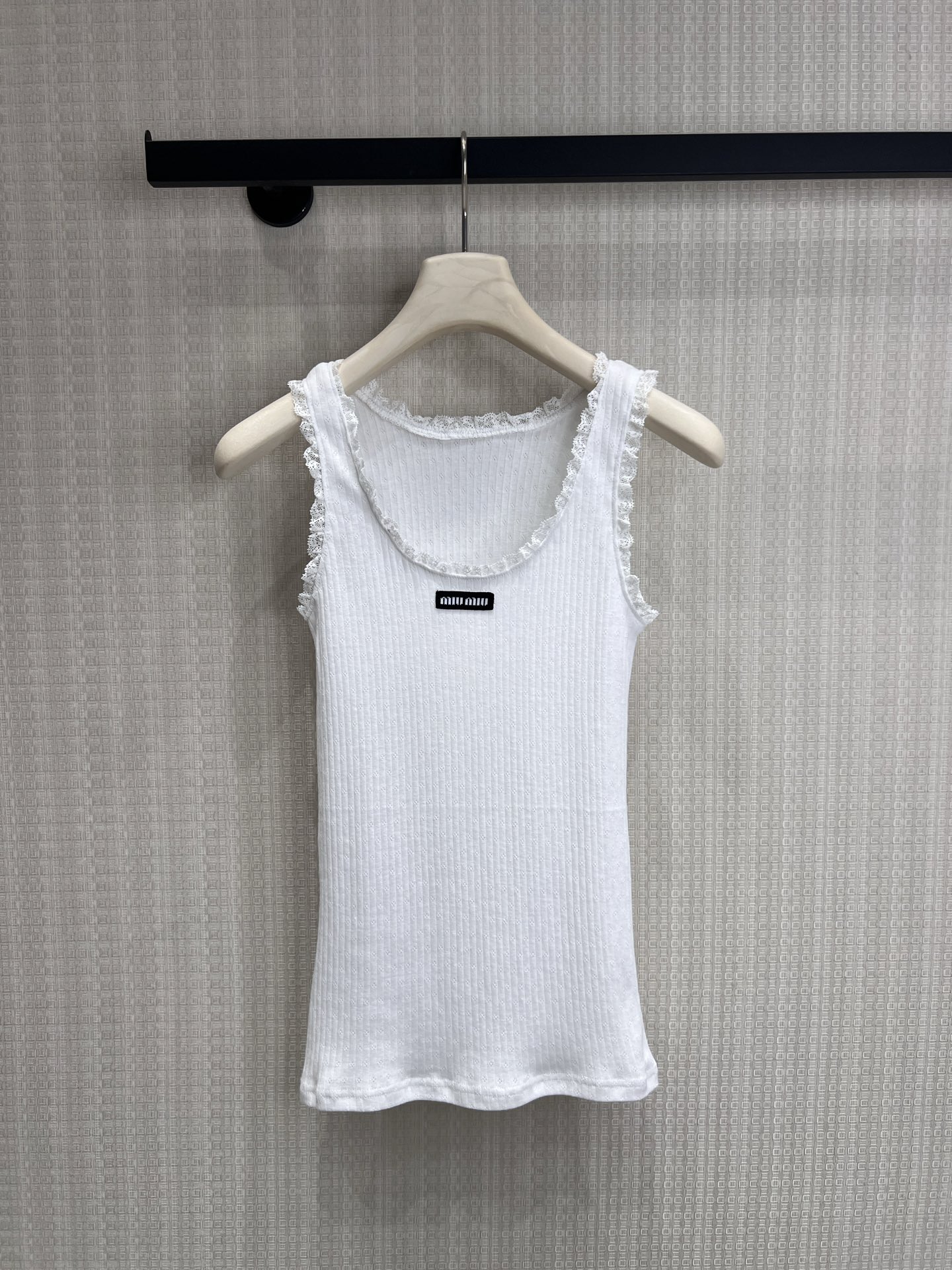 NO:845415,Short-sleeved vest 26 spring and summer new product Miu** lace white vest short-sleeved series with iconic girlish feel, the pitted texture has a soft and waxy texture, the lace on the neckline/shoulder straps is the soul detail, and paired with the brand logo woven label, it directly fills the sense of pure desire. The slim-fitting version is refreshing when worn alone and gentle when layered. It is just needed in spring and summer. Ready for sale smL,, miumiu, T-shirt,19860909短袖 背心 26春夏新品 Miu**蕾丝花边白背心 短袖系列款 标志性少女感,坑条肌理自带软糯质感,领口/肩带的蕾丝花边是灵魂细节,搭配品牌logo织标,纯欲感直接拉满.修身不勒肉的版型,单穿清爽、叠穿温柔,春夏刚需款.现货出售smL,,miumiu,T-shirt,,Women's clothing