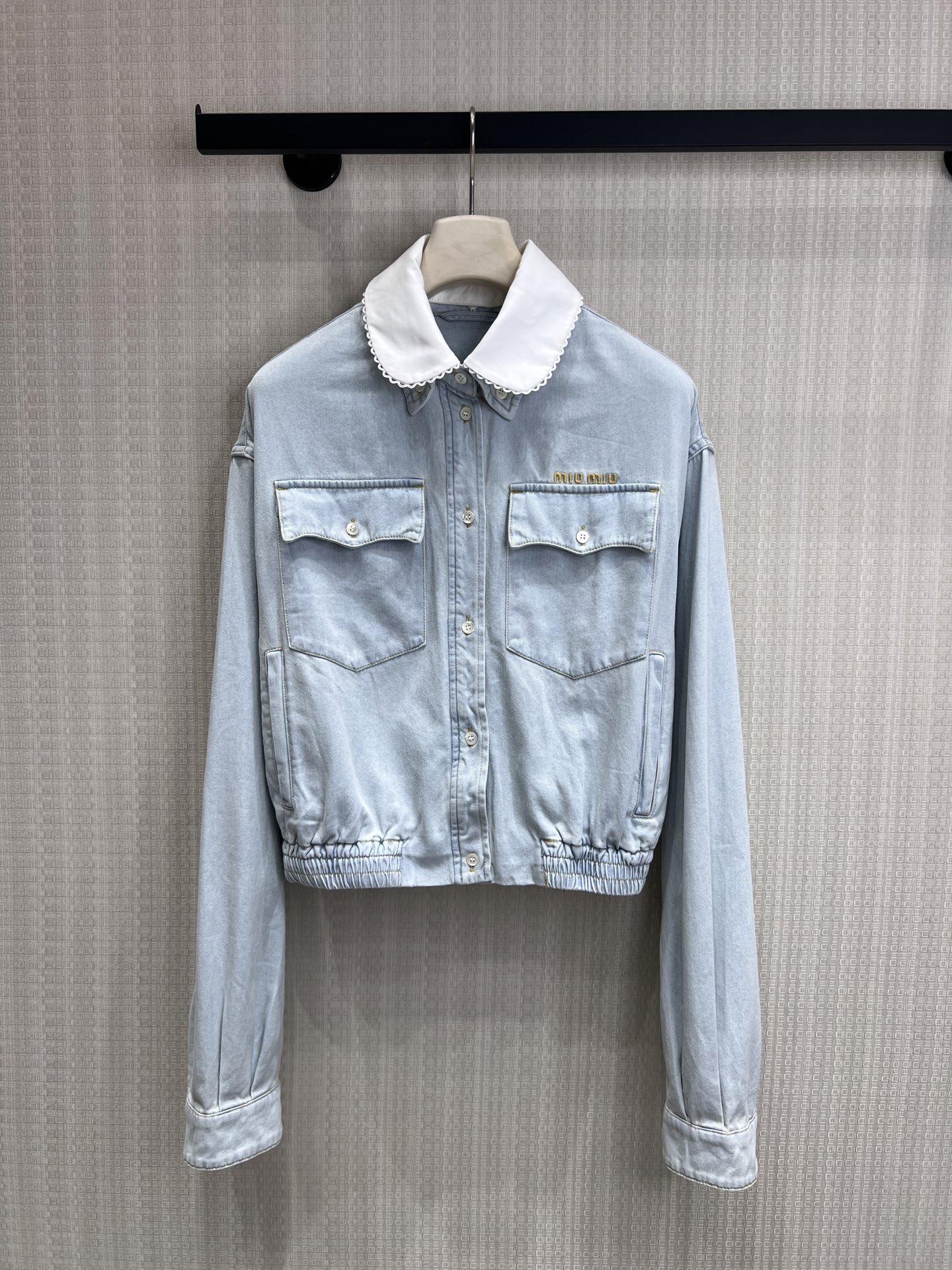 NO:845407,26 spring and summer new arrival Miu** doll collar denim jacket  The light-washed blue denim fabric has a retro soft-focus feel, and the detachable white lace baby collar is the finishing touch. The sweet element collides with the spontaneity of denim. The gold embroidered logo on the body is a low-key identity, and the elasticated hem creates a neat short version, which can easily raise the waistline and is suitable for high-waisted bottoms. The dropped shoulder cut weakens the shoulder line and brings a lazy and relaxed feeling. It is an iconic item of sweet and cool girl style. Ready for sale smL,, miumiu, jackets & coats,1986090926春夏新品 Miu**娃娃领牛仔外套 浅水洗蓝牛仔面料自带复古柔焦感,可拆卸白色蕾丝娃娃领是点睛之笔,甜美元素碰撞牛仔的率性.衣身金色刺绣Logo低调标识身份,下摆松紧收口打造利落短款版型,轻松拉高腰线,适配高腰下装.落肩剪裁弱化肩线,自带慵懒松弛感,是甜酷少女风的标志性单品.现货出售smL,,miumiu,jackets & coats,,Women's clothing