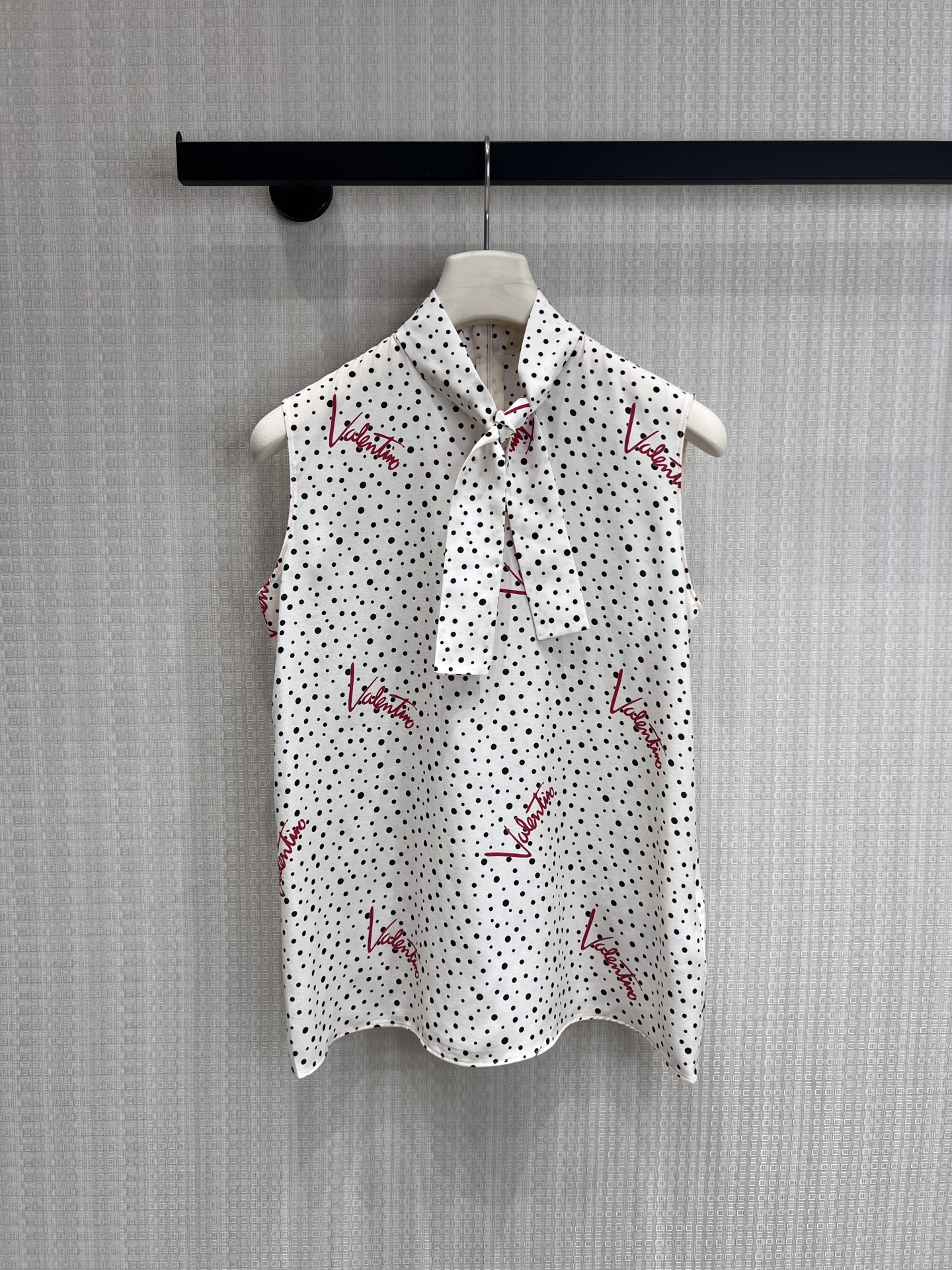 NO:845428,26 spring and summer new product Vale** signature polka dot ribbon shirt. Selected drape silk satin fabric, smooth to the touch and with high-end luster. Black and white polka dot base, with iconic red tone signature print, full of recognition. Collar tie design, can be tied or loose, easily create a French relaxed feeling. Sleeveless cut, suitable for suits, skirts, trousers and other combinations. It is a treasure item in the wardrobe to enhance sophistication.  Ready for sale smL,,valentino,skirts,shirts,business suit,real silk,1986090926春夏新品 Vale**签名波点飘带衬衫 甄选垂感真丝缎面料,手感柔滑自带高级光泽 黑白波点基底,搭配标志性红调签名印花,辨识度拉满 领口系带设计,可系可散,轻松营造法式松弛感 无袖剪裁利落,适配西装、半裙、西裤等多种搭配 是衣柜里提升精致度的宝藏单品 现货出售smL,,valentino,skirts,shirts,business suit,real silk,,Women's clothing
