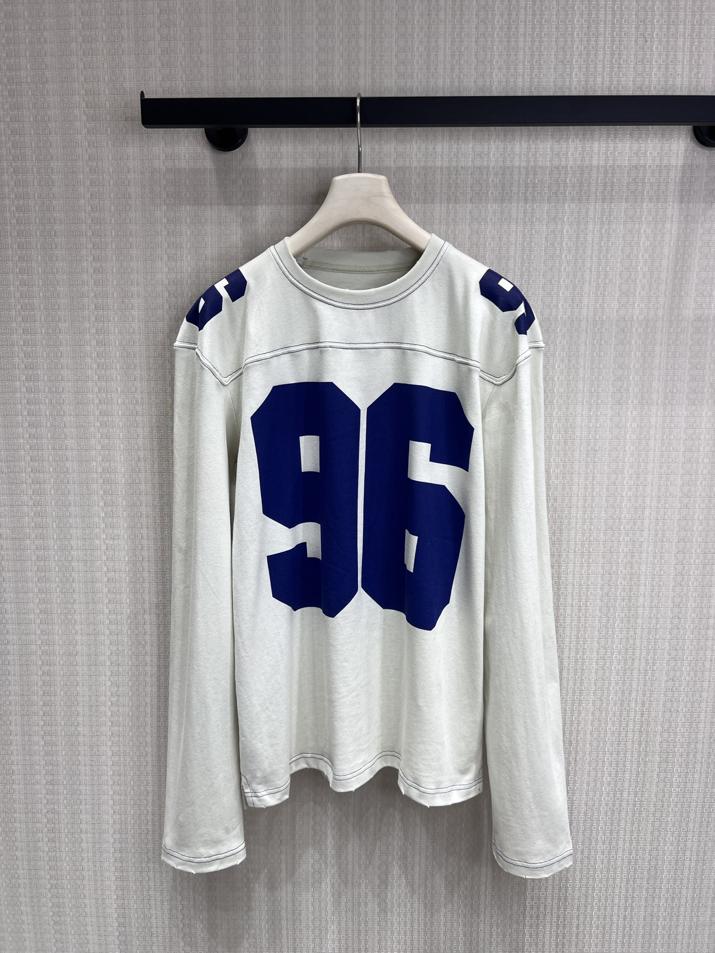 NO:845402,26 spring and summer new products Ac**  Retro old-style digitally printed long-sleeved T-shirt, light beige background with royal blue '96' contrast design, with a sense of street relaxation. The old washed process, raw edge hem and shoulder details restore the vintage texture, and the loose dropped shoulder version is not flattering on the figure, hiding flesh and casual. It can be worn alone to create a lazy American style, or can be used as a layered inner layer to easily wear an effortless high-street atmosphere. Ready for sale sml, tees, t-shirt,1986090926春夏新品 Ac** 复古做旧风数字印花长袖T恤,浅米底色搭配宝蓝色“96”撞色设计,自带街头松弛感.做旧水洗工艺,毛边下摆与肩部细节还原古着质感,宽松落肩版型不挑身材,藏肉又随性.可单穿打造慵懒美式风,也可作为叠搭内搭,轻松穿出不费力的高街氛围.现货出售smL,,tees，t-shirt,,Women's clothing