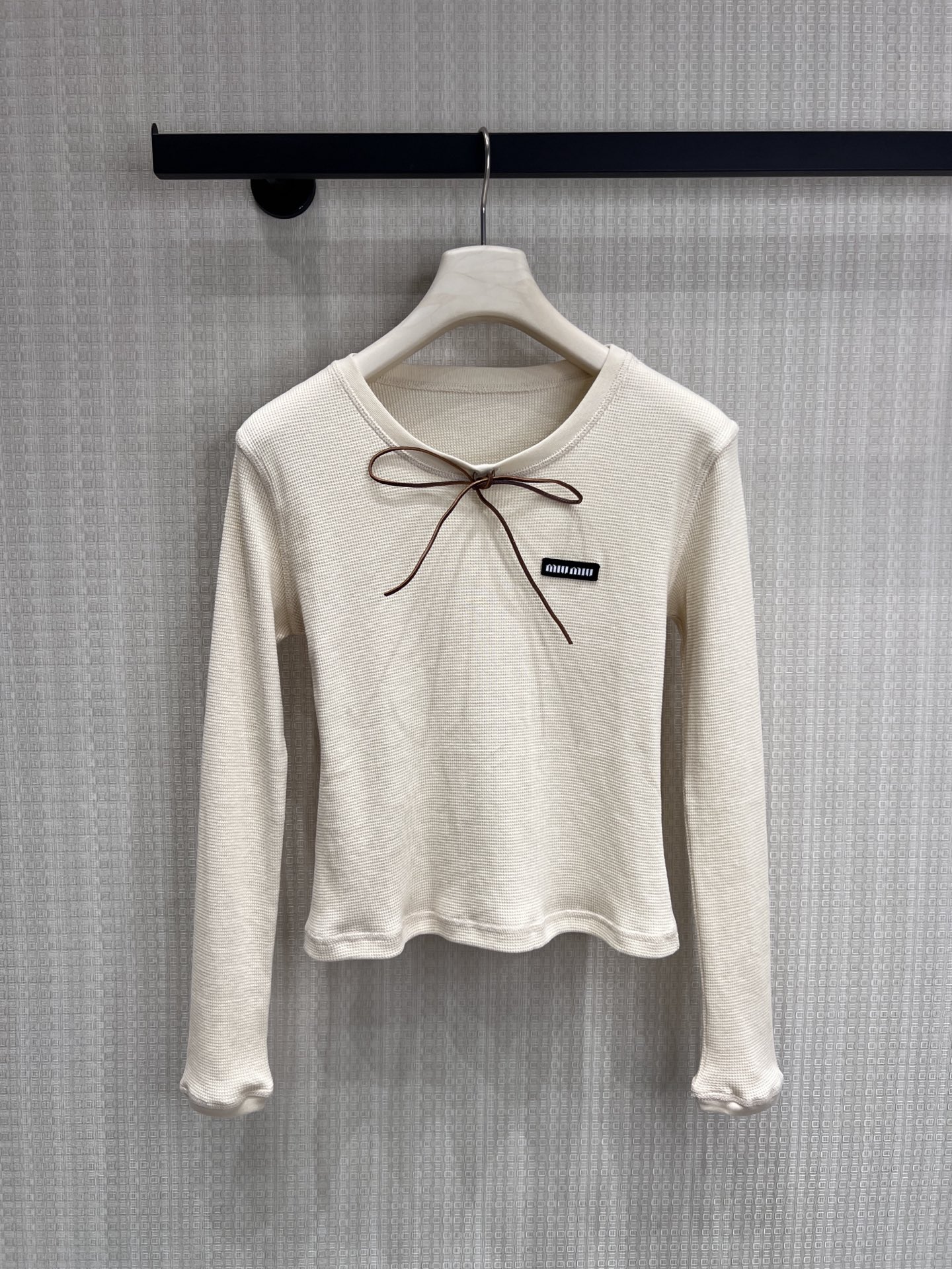 NO:857160,20 spring and summer new product Miu** style sweet and cool waffle long-sleeved top. Soft and skin-friendly textured fabric, bow and brand logo inject retro college feel, slim and not tight version, easy to achieve girly feel and daily adaptability, can be matched in all seasons. Ready for sale smL,, miumiu,1986090920春夏新品 Miu**式甜酷穿在身上的华夫格长袖 上衣.软糯亲肤的肌理面料,蝴蝶结与品牌标注入复古学院感,修身不紧绷的版型,轻松拿捏少女感与日常适配度,四季都能搭.现货出售smL,,miumiu,,Women's clothing