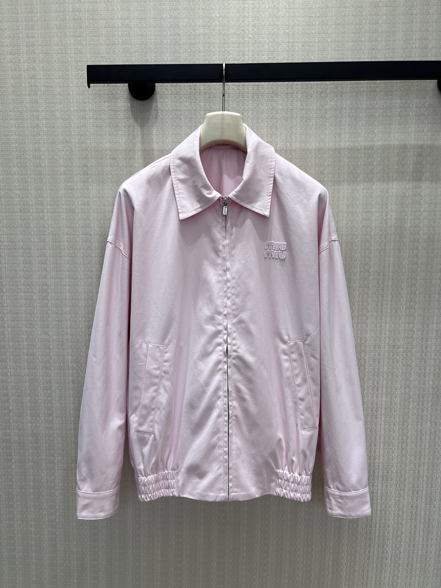 NO:867328,New product for spring and summer 26, pink MIU** jacket, with minimalist tailoring to interpret a relaxed and high-end feel. The soft light pink color comes with a cooling filter, the lapel + zipper design is neat and elegant, and the logo embossed on the chest is low-key and noble. The loose silhouette and gathered hem balance neatness and casualness, and the fabric is drapey and breathable. It is the trump card of effortless dressing in spring, and it is easy to achieve the cool rich family atmosphere. Ready for sale smL,, miumiu, jackets &  coats,jackets & coats,1986090926春夏新品 粉色系MIU**夹克外套 ,以极简剪裁诠释松弛高级感.柔和的浅粉色自带清冷滤镜,翻领+拉链设计利落大气,胸前压印logo低调显贵.宽松廓形与收束下摆平衡利落与随性,面料垂坠透气,是春日里不费力的穿搭王牌,轻松拿捏清冷富家千金氛围.现货出售smL,,miumiu,jackets & coats,jackets & coats,,Women's clothing