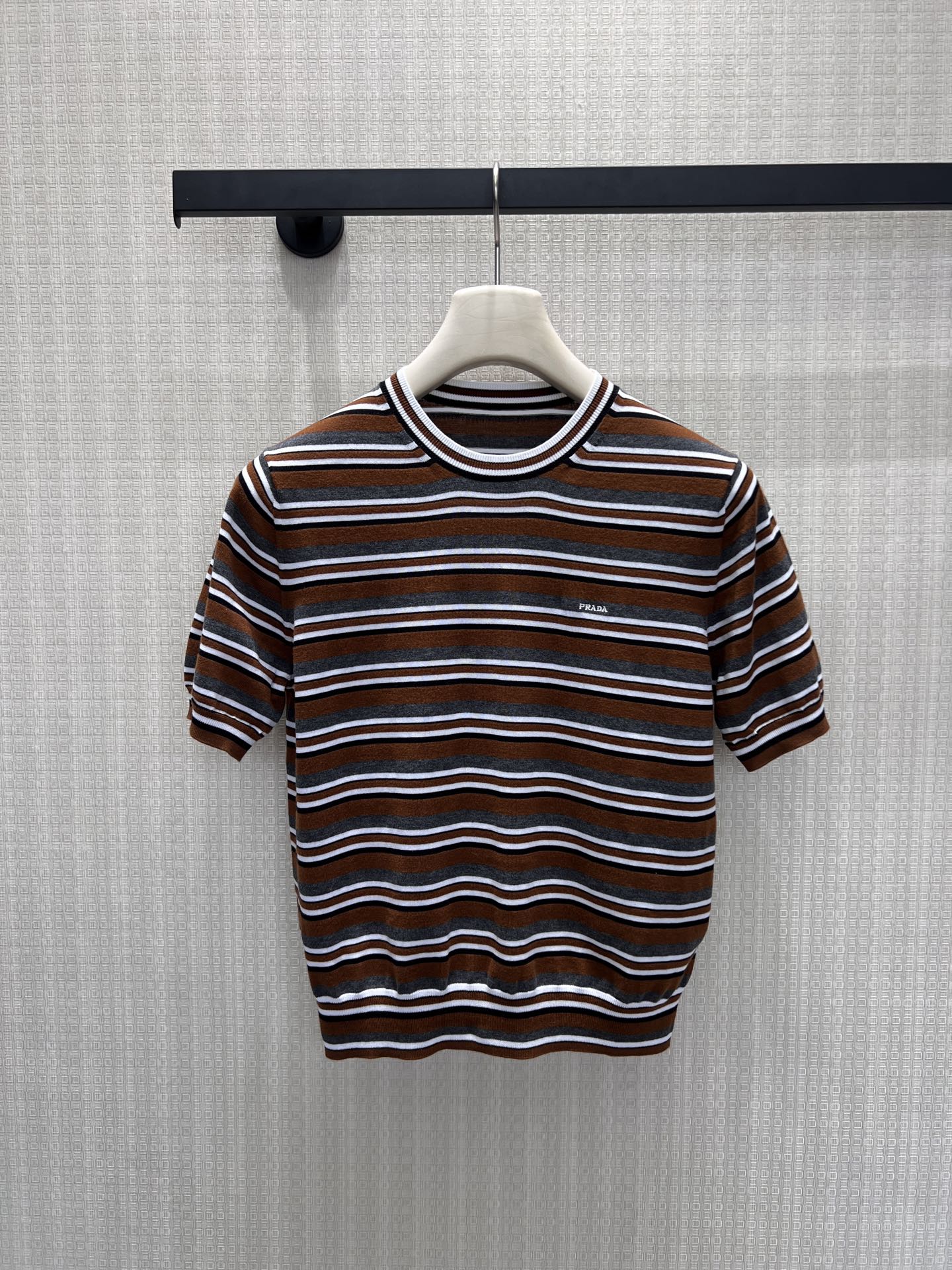 NO:867230,26 new spring and summer short-sleeved sweaters  Pra** retro brown tone striped knitted T-shirt reshapes minimalist aesthetics with classic stripes. Delicate knitting outlines a neat silhouette, brown, gray, and white contrasting stripes come with a retro filter, and the low-key brand logo on the chest hides the style. The round neck and short sleeves are neatly cut, and the soft and stylish texture is suitable  Paired with a variety of scenes, you can wear it alone or layered to create a Prada-style restrained and high-end look. It is a timeless textured item in your wardrobe. Available in stock, smL, prada, sweaters, T-shirts, tees, t-shirts,1986090926春夏新品短袖毛衣 Pra**复古棕调条纹针织T恤,以经典条纹重塑极简美学.细腻针织勾勒利落版型,棕、灰、白撞色条纹自带复古滤镜,胸口低调品牌标识暗藏格调.圆领与短袖剪裁利落,软而有型的质感适配多种场景,单穿或叠搭都能穿出Prada式的克制高级,是衣橱里永不过时的质感单品.现货出售smL,,prada,sweaters,T-shirt,tees，t-shirt,,Women's clothing