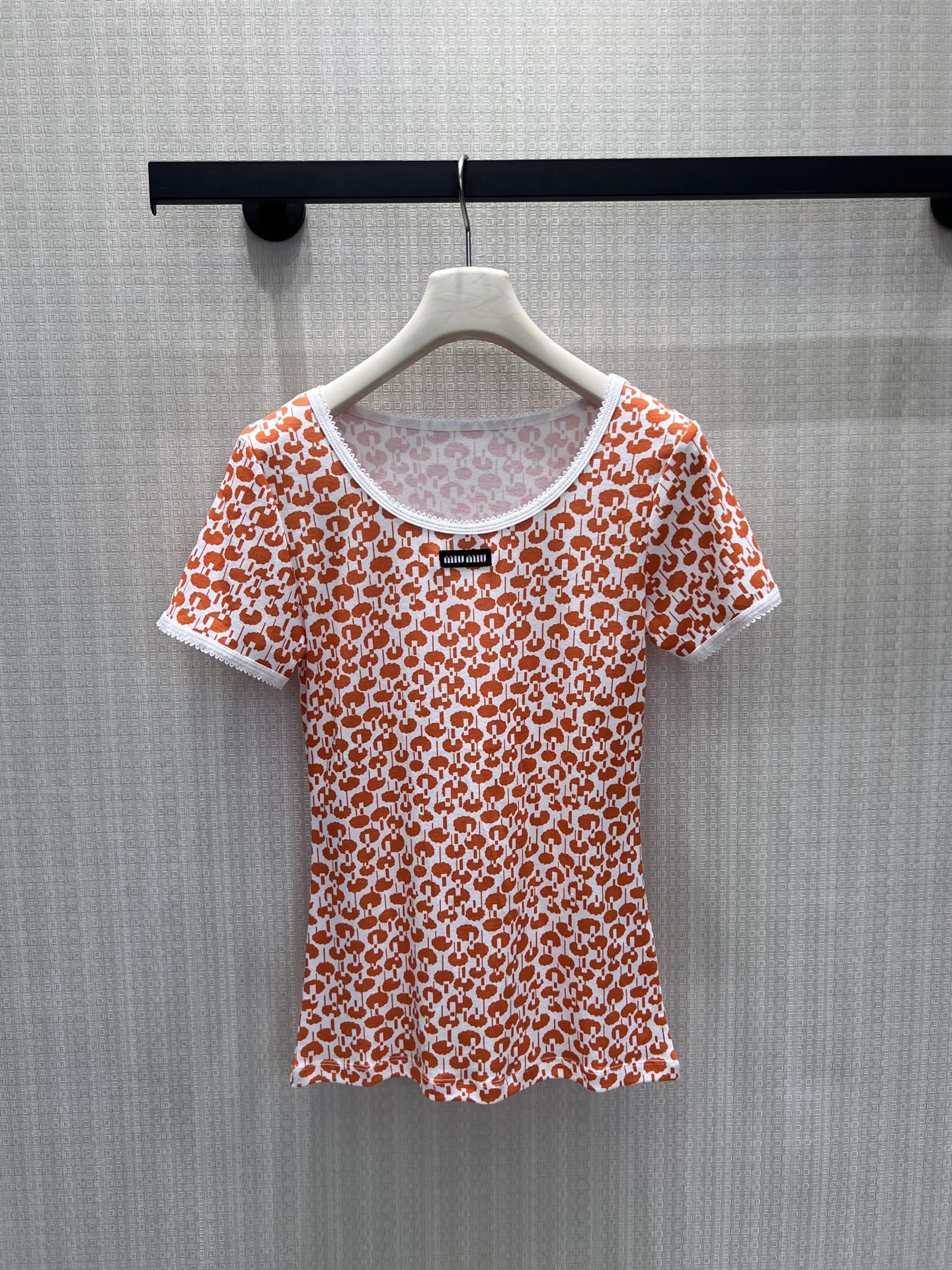 NO:869844,26 spring and summer new products  Miu's orange-toned all-over printed short sleeves feature the brand's logo pattern on the body, giving it a sweet but not greasy girly vibe. The round neck is paired with lace to outline soft lines, and the woven label on the chest highlights the brand's heritage. The slim fit fits the body shape, outlines the waist curve, and is skin-friendly.  The material combines comfort and texture. Pair it with skirts or jeans for daily use, and you can easily balance the retro sweet girl with exquisite daily life. It is a dazzling item in the wardrobe. Available in stock smL, miumiu, skirts, jeans, T-shirt,1986090926春夏新品 Miu家橘调满印短袖,将品牌标识化图案铺陈于衣身,自带甜而不腻的少女氛围.大圆领搭配蕾丝包边,勾勒柔和线条,胸口织唛点明品牌底蕴.修身版型贴合身形,勾勒腰肢曲线,亲肤面料兼顾舒适与质感.日常搭配半裙或牛仔裤,轻松拿捏复古甜妹与精致日常的平衡,是衣橱里的亮眼单品.现货出售smL,,miumiu,skirts,jeans,T-shirt,,Women's clothing