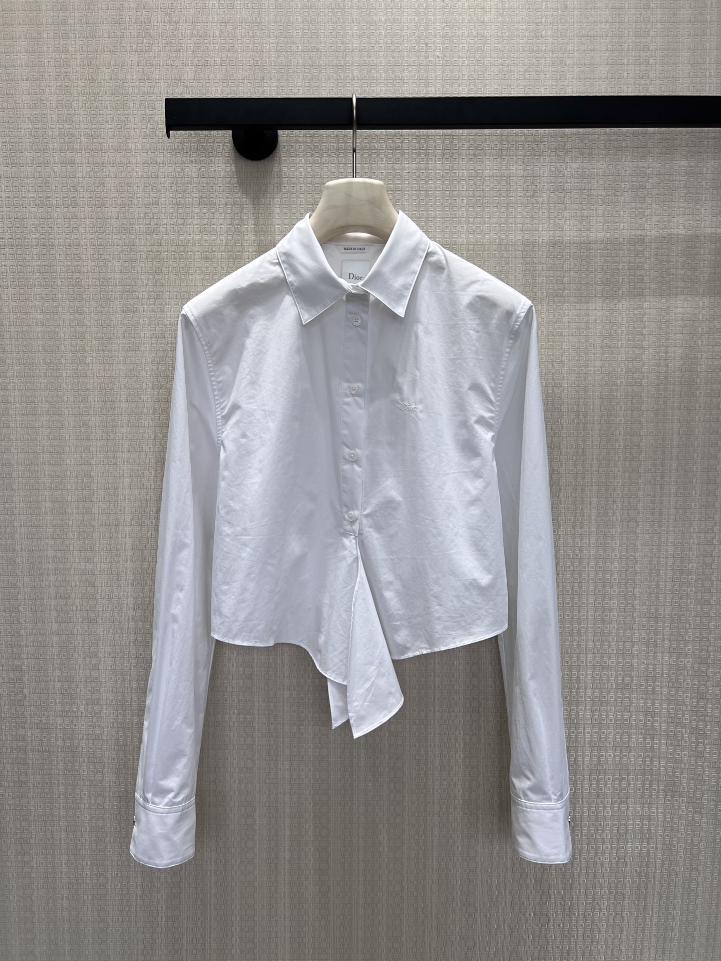 NO:886289,The elegance of the 26 spring and summer new Dio** white shirt is hidden in the details. The crisp cotton poplin outlines neat lines, the short tailoring breaks the rules, and the asymmetric hem hides ingenuity. The embroidered logo on the chest tells the brand's heritage in a low-key manner, and the neat lapels and mother-of-pearl buttons combine the classic and the avant-garde. The white shirt is not only a basic style, but also synonymous with high-end, suitable for every undefined exquisite daily life. Ready for sale smL, dior, shirts,1986090926春夏新品 Dio**白衬衫的优雅,藏在细节里.挺括棉府绸勾勒利落线条,短款剪裁打破常规,不对称下摆暗藏巧思.胸口刺绣标识低调诉说品牌底蕴,利落翻领与珍珠母贝纽扣,将经典与先锋融合.白衬衫不止基础款,更是高级感的代名词,适配每一种不被定义的精致日常.现货出售smL,,dior,shirts,,Women's clothing