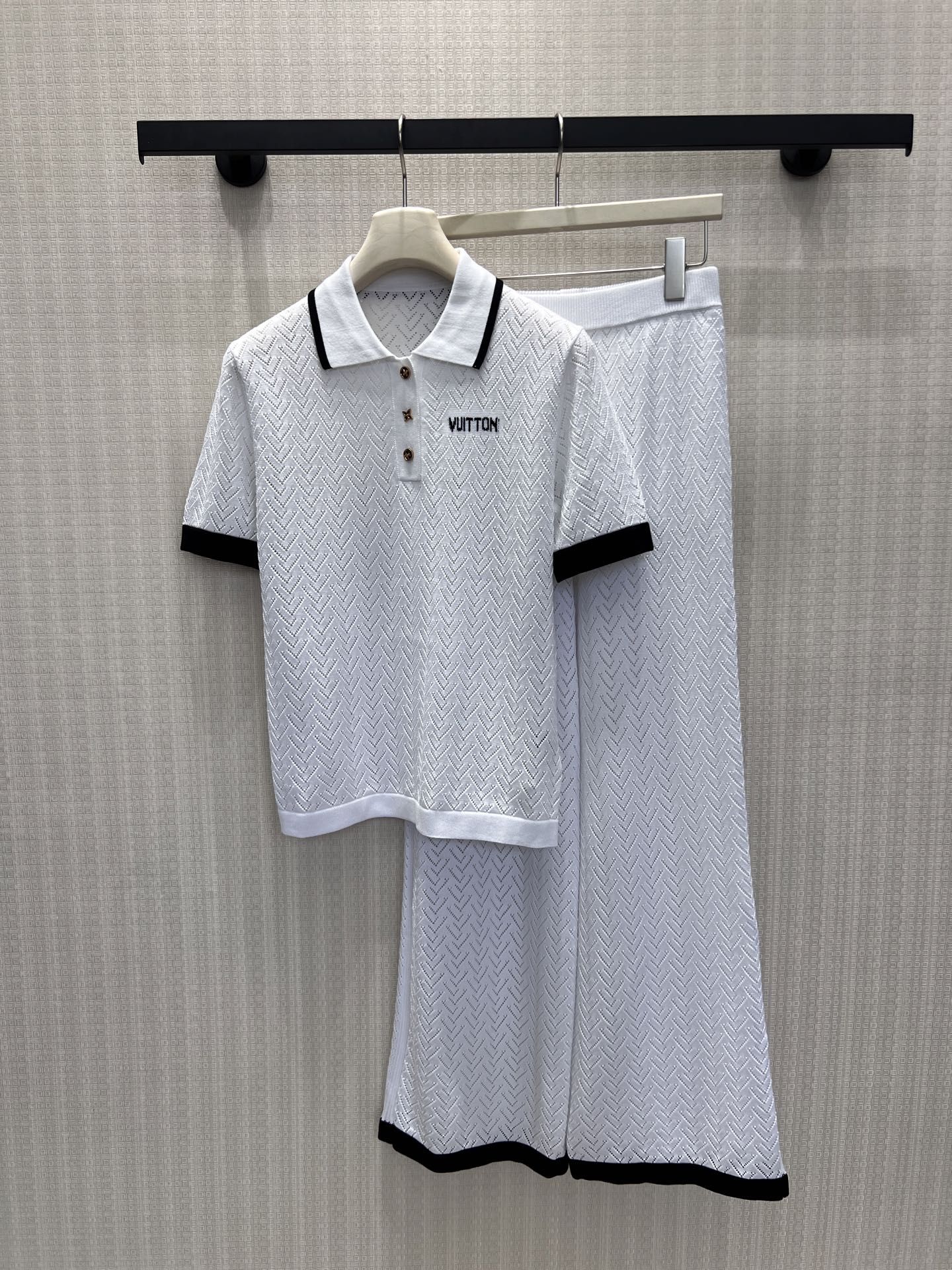 NO:877856,Tops, pants, new spring and summer suits  French light luxury style Polo knitted suit, with a dark jacquard texture all over, delicate and textured, contrasting collar and cuffs to outline exquisite details. The neat lapels are equipped with small metal buttons, and the simple letters on the chest are embellished with low-key and noble features. The top is loose and does not flatter the body shape, and is made of the same fabric.  The wide-leg trousers drape smoothly, and the contrasting color of the trousers echoes the top. The whole set of the same color combination is worry-free and labor-saving. It is soft and skin-friendly, breathable and comfortable. It can be worn casually for daily outings and afternoon tea, and can easily be worn to create a lazy and noble atmosphere of a rich family. Ready for sale smL,,19860909上衣 裤子 春夏新品套装 法式轻奢风Polo针织套装,通体暗纹提花肌理细腻有质感,撞色领边与袖口勾勒精致细节.利落翻领配金属小扣,胸口简约字母点缀低调显贵.上衣宽松不挑身形,同面料阔腿长裤垂坠顺滑,裤脚撞色呼应上衣.整套同色系搭配省心省力,软糯亲肤透气舒适,日常出行、下午茶随性上身,轻松穿出慵懒显贵的富家千金氛围感.现货出售smL,,,Women's clothing