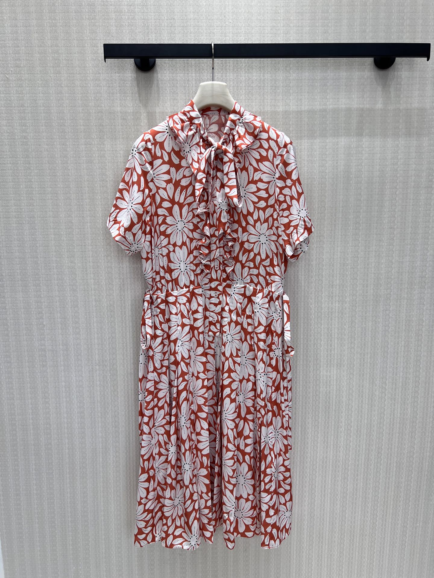 NO:878146,26 new spring and summer dresses  Pra**'s retro floral aesthetic gene uses warm brick red as the background color, hand-painted daisy prints are spread out at random, and the red and white contrasting colors bring a retro movie texture. The bow tie on the collar + the lotus leaf pleats on the placket are soft and balanced; the drawstring waistbands on both sides can be adjusted to freely outline the waistline.  , the loose body is suitable for all body shapes. The high-hanging smooth texture fabric is selected, and the pleated skirt stretches naturally with every step, blending Italian laziness and elegance. It is unintentionally elegant and can be easily adapted to various scenes. Available in stock smL, prada, skirts,1986090926春夏新品连衣裙 Pra**复古花卉美学基因,以暖调砖红铺陈底色,手绘雏菊印花错落铺展,红白撞色自带复古电影质感.领部蝴蝶结系带+门襟荷叶褶皱,柔飒平衡；双侧可调节抽绳腰头自由勾勒腰线,宽松衣身包容各类身形.甄选高垂顺肌理面料,褶裥裙摆随步履自然舒展,把意式慵懒与优雅糅合,不刻意的奢雅,从容适配多场景穿搭.现货出售smL,,prada,skirts,,Women's clothing