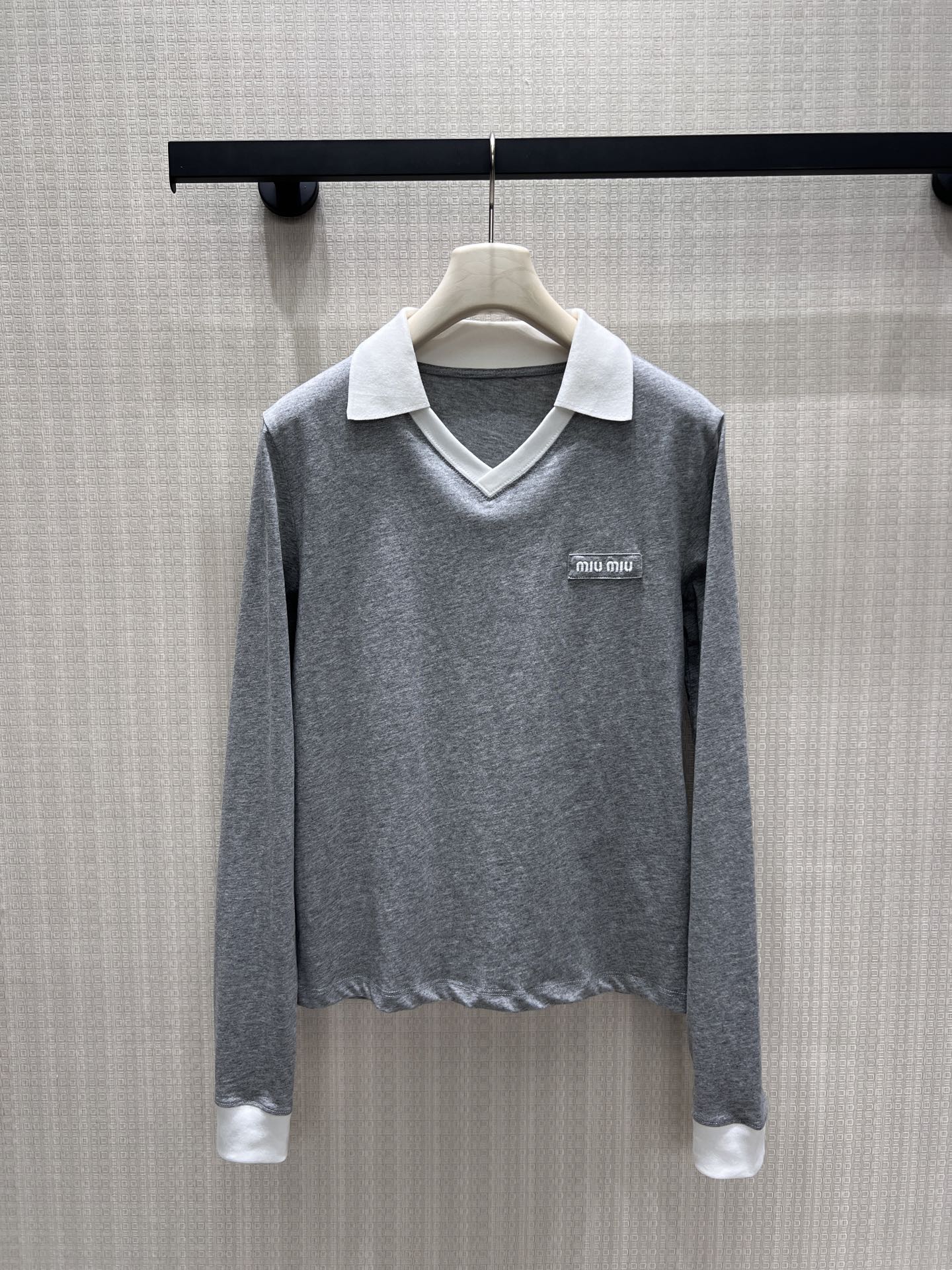 NO:878481,26 spring and summer new products  miu** gray contrasting white POLO collar long sleeves, replicating the light and luxurious tone of college style. Contrast color lapels and cuffs outline the layering, V-shaped neckline modifies the neck line, and exquisite small logo on the chest hides the brand texture. Soft, skin-friendly blended fabric, slightly cut at the hem  Tailored to optimize body proportions, the neat short style is suitable for high-waisted bottoms. It is relaxed and age-reducing and has a well-behaved lady atmosphere. It can be matched with your daily commuting and leisure travels. It is easy to choose a lazy and exquisite Korean style. Ready for sale smL,, miumiu,1986090926春夏新品 miu**灰撞白POLO领长袖,复刻学院风轻奢调性.撞色翻领与袖口勾勒层次,V型领口修饰脖颈线条,胸口精致小标暗藏品牌质感.软糯亲肤的混纺面料,下摆微收剪裁优化身形比例,利落短款适配高腰下装.松弛减龄又自带乖巧名媛氛围,日常通勤、休闲出游随心搭配,轻松拿捏慵懒精致的韩系穿搭.现货出售smL,,miumiu,,Women's clothing