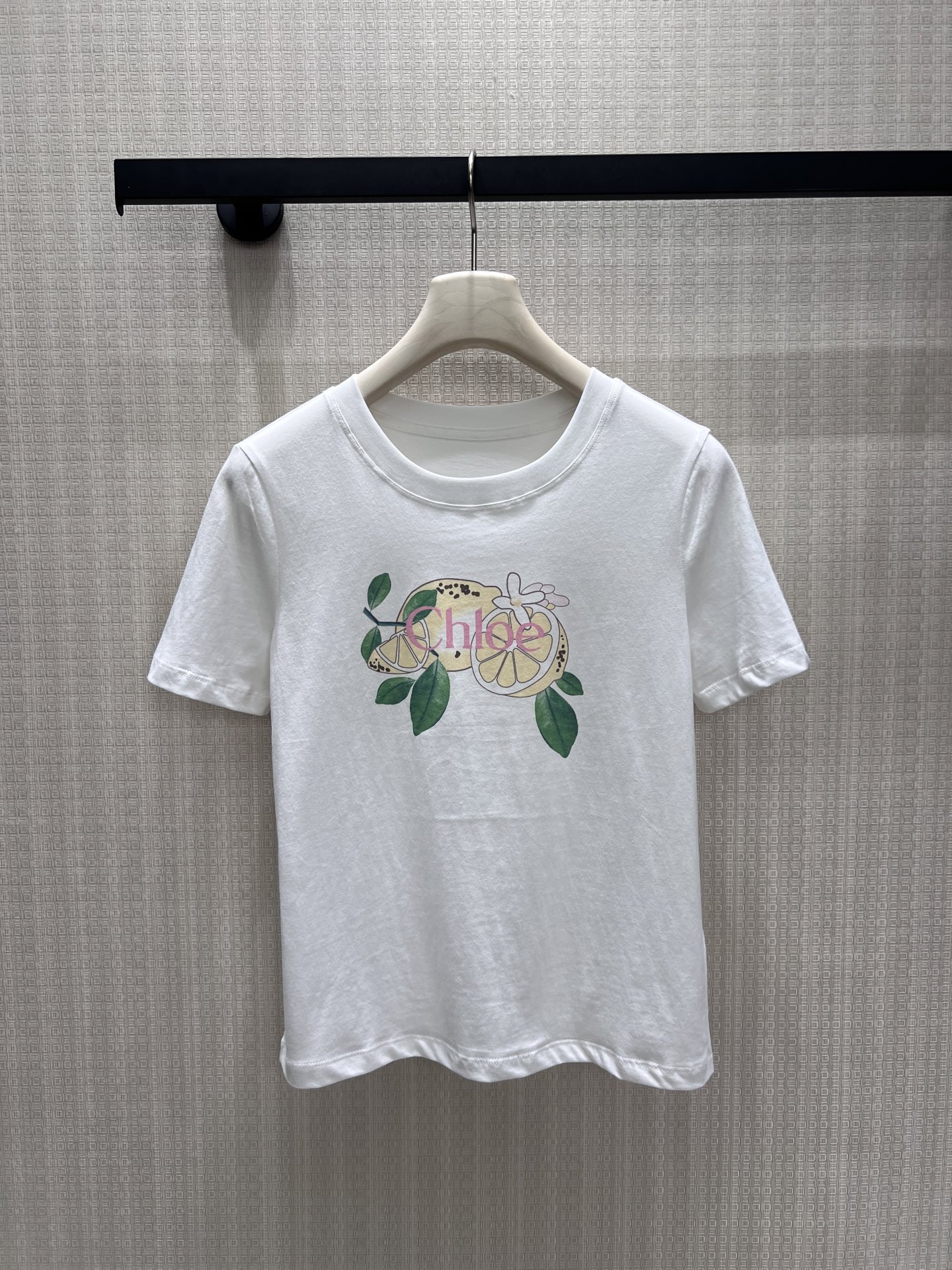 NO:886351,26 new spring and summer short-sleeved products are made of clear white cotton as the base, and are dyed with the fresh poetry of summer lemons. The hand-painted style print brings a natural sense of relaxation, and the round neck cut is neat and soft, cleverly integrating minimalism and fun. The breathable fabric fits the skin and is suitable for daily and light commuting scenes. Use a touch of fresh lemon yellow to inject a lazy and high-end relaxed atmosphere into the wardrobe. Ready for sale smL, T-shirt,1986090926春夏新品 短袖 以清透白棉为底,晕染出夏日柠檬的鲜活诗意.手绘风印花带着自然的松弛感,圆领剪裁利落柔和,将极简与趣味巧妙融合.透气面料贴合肌肤,适配日常与轻通勤场景,用一抹清新柠黄,为衣橱注入慵懒又高级的松弛氛围.现货出售smL,,T-shirt,,Women's clothing