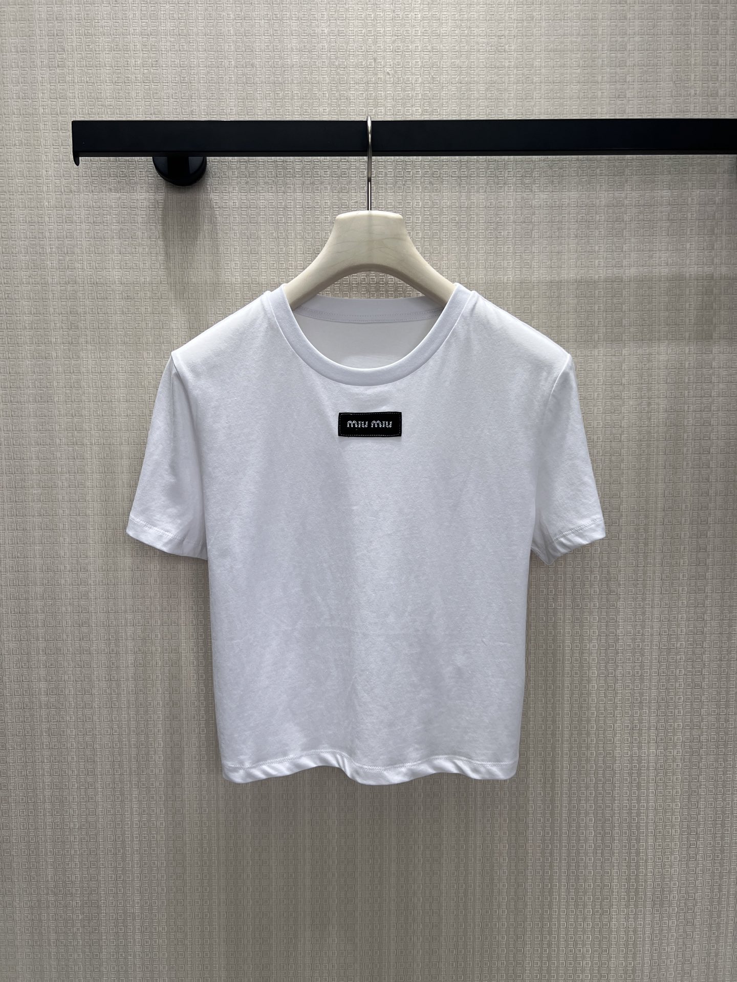 NO:891560,26 spring and summer new products short sleeves  miu**'s iconic minimalist girlish short T-shirt, with a clean pure white background that is pure and eye-catching. The small square mark is low-key and imprints the brand's genes. It is low-key and not exaggerated. The slightly narrowed short version optimizes body proportions and is friendly to small people. The round neck accommodates various neck lines. Soft, waxy and breathable cotton material  Focusing on comfort and drape, it is suitable for commuting with skirts and casual wear with jeans. It eliminates excessive sweetness and retains just the right amount of luxury and gentleness. It can be worn casually every day to give a sense of refinement and elegance. In stock, smL, miumiu, skirts, T-shirts,1986090926春夏新品 短袖 miu**标志性极简少女感短T,干净纯白底色纯粹耐看,小方标低调烙印品牌基因,低调不浮夸.微收短款版型优化身材比例,小个子友好,圆领包容各种脖颈线条.软糯透气棉料兼顾舒适与垂感,通勤配半裙、休闲搭牛仔皆适配,褪去过度甜腻,保留恰到好处的轻奢温柔,日常随手穿出精致贵气感.现货smL,,miumiu,skirts,T-shirt,,Women's clothing