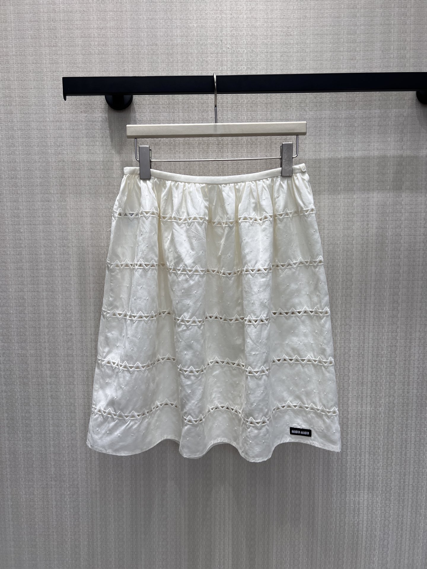 NO:893077,26 spring and summer new products  Miu hollow skirt. The clean creamy white color sets the tone of elegance, and the fine detailing throughout adds fabric details. The horizontal hollow stripes are staggered and intertwined, making it transparent and agile when walking. The waist is naturally pleated and stretched into a loose A-line, which accommodates all kinds of hip and leg lines, and the length is just right.  Decorated with calf lines. The low-key black label balances sweetness and high-end. It is paired with the same series of striped long-sleeved and puff-sleeved tops as a complete set. It is an Italian girly item with its own soft light filter. In stock 36/38/40, miumiu, skirts,1986090926春夏新品 Miu镂空半裙.干净奶白奠定素雅基调,满幅细碎提点增添面料细节,横向镂空条纹错落交织,行走间通透灵动.腰部自然抽褶舒展成宽松A字,包容各类臀腿线条,长度刚好修饰小腿线条.低调黑标平衡甜美与高级,搭配同系列条纹长袖、泡泡袖上衣成套出镜,是自带柔光滤镜的意式少女单品.现货36/38/40,,miumiu,skirts,,Women's clothing