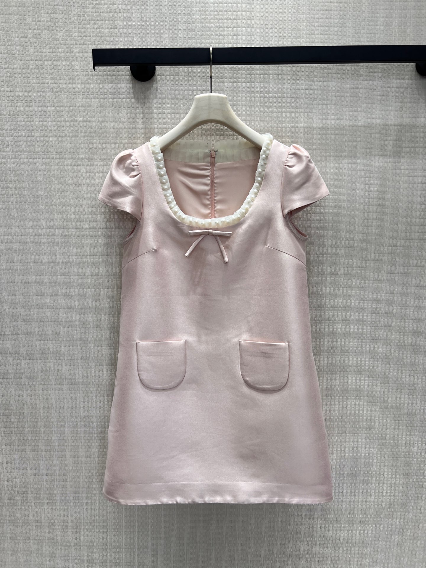 NO:893401,26 spring and summer new products, original designer dress, soft matte light pink satin, interpreting the feeling of a gentle girl. The U-shaped neckline is surrounded by handmade pearl trim, with a bow of the same color in the middle, which is exquisite and soft to highlight the beautiful shoulders and neck. Retro small flying sleeves modify the arm lines, double patch pockets on the front add a retro atmosphere, and the neat straight version hides the flesh and makes you look slimmer. The delicate satin has a soft light texture, the invisible zipper on the back is easy to put on and take off, and the low-saturated nude pink is gentle and noble.  Spot smL,,skirts,1986090926春夏新品 原创设计师款连衣裙 柔雾浅粉缎面 诠释温柔千金少女感.U型领口环绕手工珍珠饰边,正中搭配同色系蝴蝶结,精致柔和衬出优美肩颈.复古小飞袖修饰手臂线条,前身双贴口袋增添复古氛围,利落直筒版型藏肉显瘦.细腻缎面自带柔光质感,后身隐形拉链穿脱便捷,低饱和裸粉温柔显贵 现货smL,,skirts,,Women's clothing