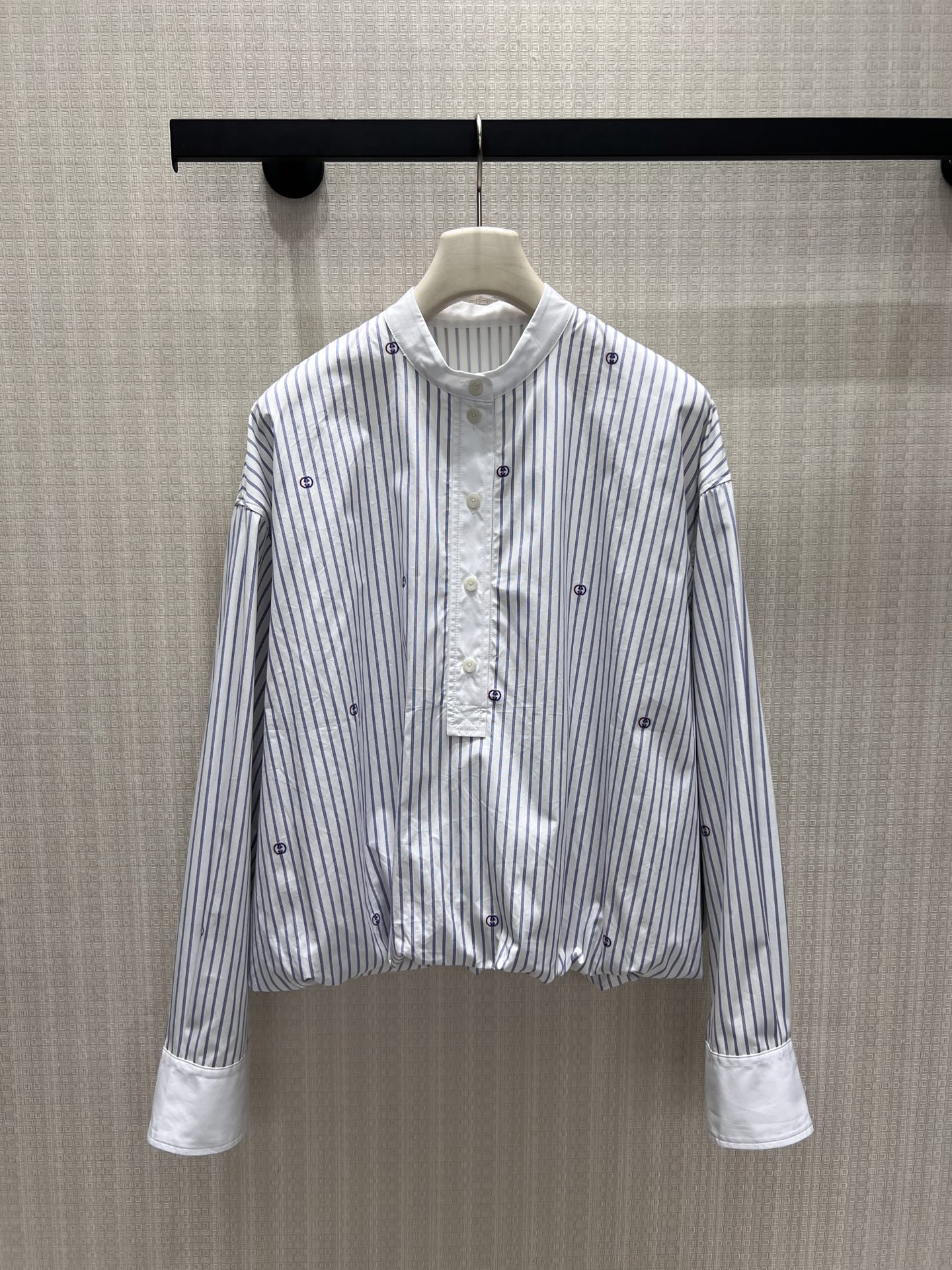 NO:908601,26 new spring and summer shirts. Light blue pinstripes bring a refreshing atmosphere, and scattered double G embroidery low-key reveals the brand's heritage. The stand-up collar and half-open buttons weaken the seriousness of commuting, and the pleated short tailoring at the hem optimizes the proportions. The contrasting wide cuffs hide exquisite ingenuity. The loose off-shoulder version accommodates all body shapes, is simple and not exaggerated, and takes into account daily casualness and light luxury texture. It can be easily adapted to skirts and trousers, showing a timeless retro elegance. In stock 36/38/40  Actual detailed pictures,,skirts,shirts,1986090926春夏新品衬衫 浅蓝细条纹自带清爽氛围感,散落双G刺绣低调释放品牌底蕴.立领半开扣弱化通勤严肃感,下摆收褶短款剪裁优化比例,撞色宽袖口暗藏精致巧思.宽松落肩版型包容各类身形,简约不浮夸,兼顾日常随性与轻奢质感,轻松适配半裙、西裤,演绎永不过时的复古优雅.现货36/38/40 实拍细节图,,skirts,shirts,,Women's clothing
