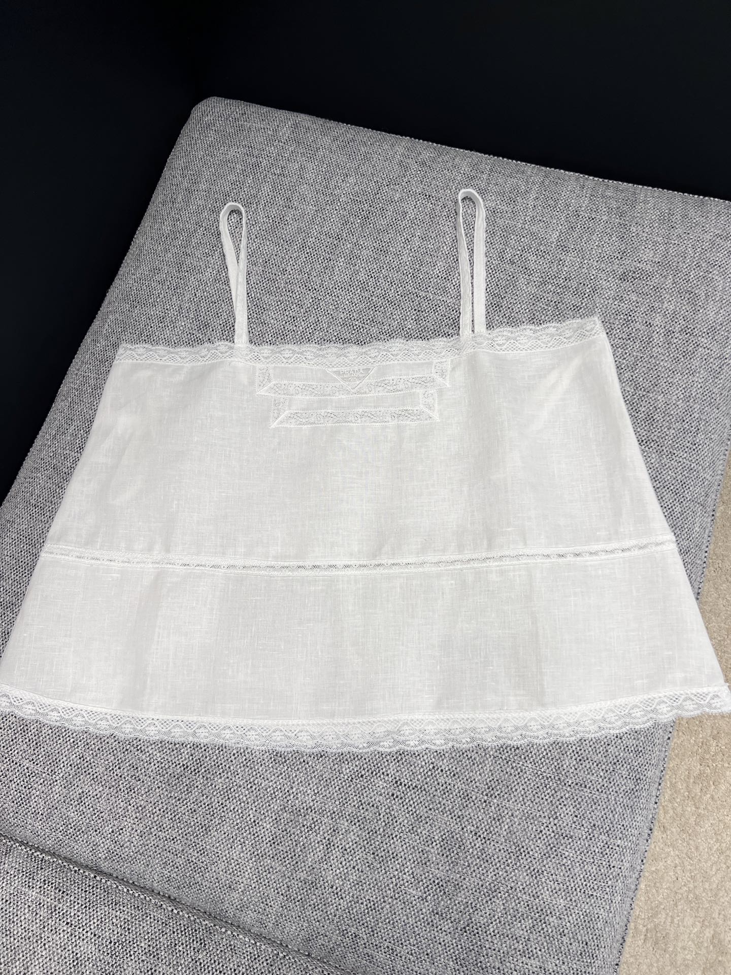NO:909313,26 spring and summer new products pra**  Pure linen sling with French style atmosphere, with soft texture, clean milky white tone, gentle and healing. The whole body is spliced with exquisite hollow lace, the layered lace design on the chest weakens the monotony, and the double-layer cake version cleverly modifies the body shape  .The spaghetti straps are simple and neat. They can be worn alone to create a relaxed feeling, or can be worn as a layered shirt or knitted cardigan. It is refreshing and breathable, suitable for spring and summer, and has a lazy girly atmosphere. Ready in stock 36/38/40  Actual detailed pictures, prada, shirts,1986090926春夏新品 pra** 法式氛围感纯亚麻吊带,自带柔和肌理质感,干净奶白调温柔又治愈.周身拼接精致镂空蕾丝,胸口层次花边设计弱化单调感,双层蛋糕版型巧妙修饰身形.细肩带简约利落,既能单穿打造纯欲松弛感,也可作为内搭叠穿衬衫、针织开衫,清爽透气适配春夏,慵懒少女氛围感随手拿捏.现货36/38/40 实拍细节图,,prada,shirts,,Women's clothing