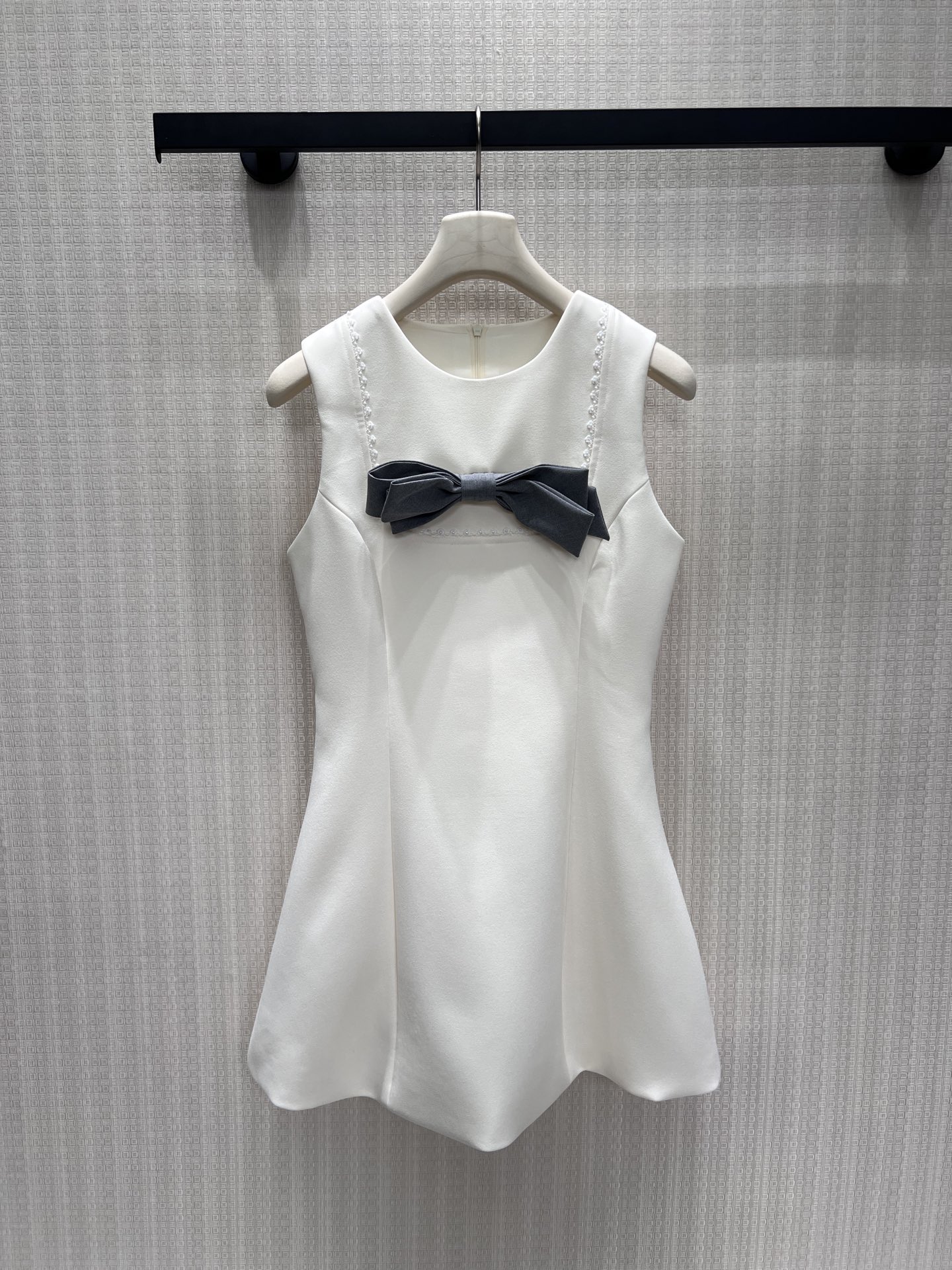 NO:925213,26 spring and summer new products. Off-white sleeveless dress has a neat and crisp silhouette, with a contrasting gray bow on the chest, and fine beading on the collar to enhance sophistication. The waist is neatly nipped in to tighten the waistline, and the A-line spread skirt modifies the crotch and optimizes body proportions. The fabric drapes smoothly and is not easy to wrinkle. The overall style is sweet and dignified, suitable for dating and light social occasions. The upper body shows a gentle and elegant temperament, easily creating a clean and elegant atmosphere. Ready-to-wear smL  Actual detailed pictures,,skirts,1986090926春夏新品 米白无袖连衣裙版型利落挺括,胸口灰色蝴蝶结撞色点睛,领边细密钉珠强化精致度.利落收腰收紧腰线,A字散开裙摆修饰胯部、优化身材比例.面料顺滑垂坠不易起皱,整体风格清甜端庄,适配约会、轻社交场合,上身尽显温柔千金气质,轻松塑造干净雅致的氛围感穿搭现货smL 实拍细节图,,skirts,,Women's clothing
