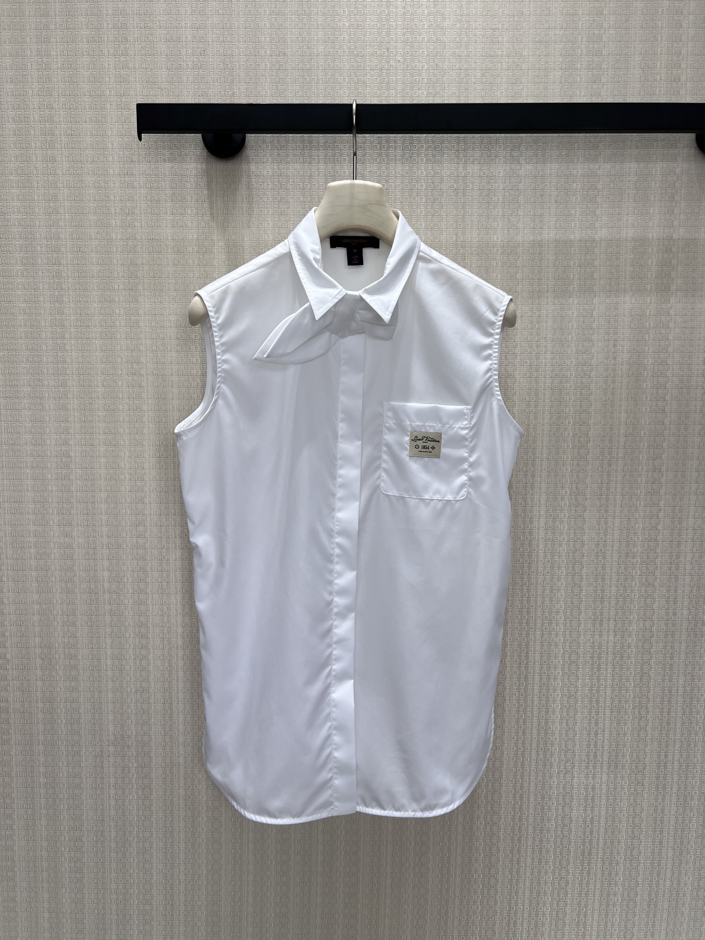NO:911320,26 new spring and summer shirts. Sleeveless tailoring, crisp and neat, pointed collar with unique bow tie design, blending girlish tenderness and French luxury. The patch label on the chest hides the brand details, the curved hem modifies the body shape, and the loose version accommodates all body types. It is refreshing and elegant to wear alone, with long sleeves underneath for outstanding layering. The simple white shirt breaks away from the monotony of basic styles, is low-key and refined, and can be worn for daily commuting with a calm and high-end atmosphere. In stock 36/38/40  Actual detailed pictures, shirts,1986090926春夏新品 衬衫 无袖剪裁清爽利落,尖领搭配别致领结设计,糅合少女温柔与法式轻奢.胸前贴布标签暗藏品牌细节,弧形下摆修饰身形,宽松版型包容各种身材.单穿清爽雅致,内搭长袖叠穿层次出众,简约白衬衫跳出基础款单调,低调精致,通勤日常都能穿出从容高级氛围感.现货36/38/40 实拍细节图,,shirts,,Women's clothing