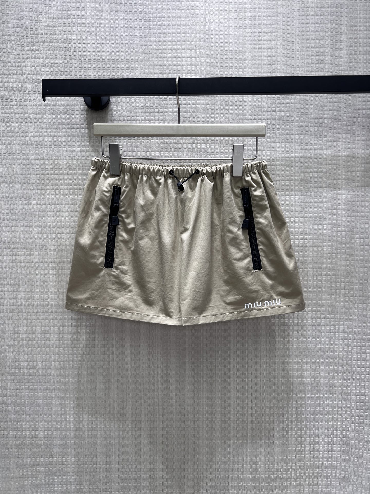 NO:912117,miu** 26 new spring and summer suit. The gentle milk tea khaki tone is full of girlish relaxation. The stand-up collar drawstring jacket is loose and dropped on the shoulders, and the simple letter embroidery on the chest is low-key and exquisite. It is matched with a drawstring skirt of the same color, and the length is balanced to create a superior ratio of 30 to 70. The light and breathable fabric is suitable for daily travel, and the neat black zipper embellishes the details. The upper body of the set is lazy and noble, and it is easy to wear simple and casual outfits with rich gold style. In stock 36/38/40  Actual detailed pictures,,miumiu,skirts,jackets & coats,19860909miu** 26春夏新品套装 温柔奶茶卡其调满溢少女松弛感,立领抽绳夹克宽松落肩,胸前简约字母刺绣低调精致.配套同色系抽绳短裙,长短平衡打造三七分优越比例.轻薄透气面料适配日常出行,利落黑拉链点缀细节,成套上身慵懒又显贵,轻松拿捏千金风简约休闲穿搭.现货36/38/40 实拍细节图,,miumiu,skirts,jackets & coats,,Women's clothing