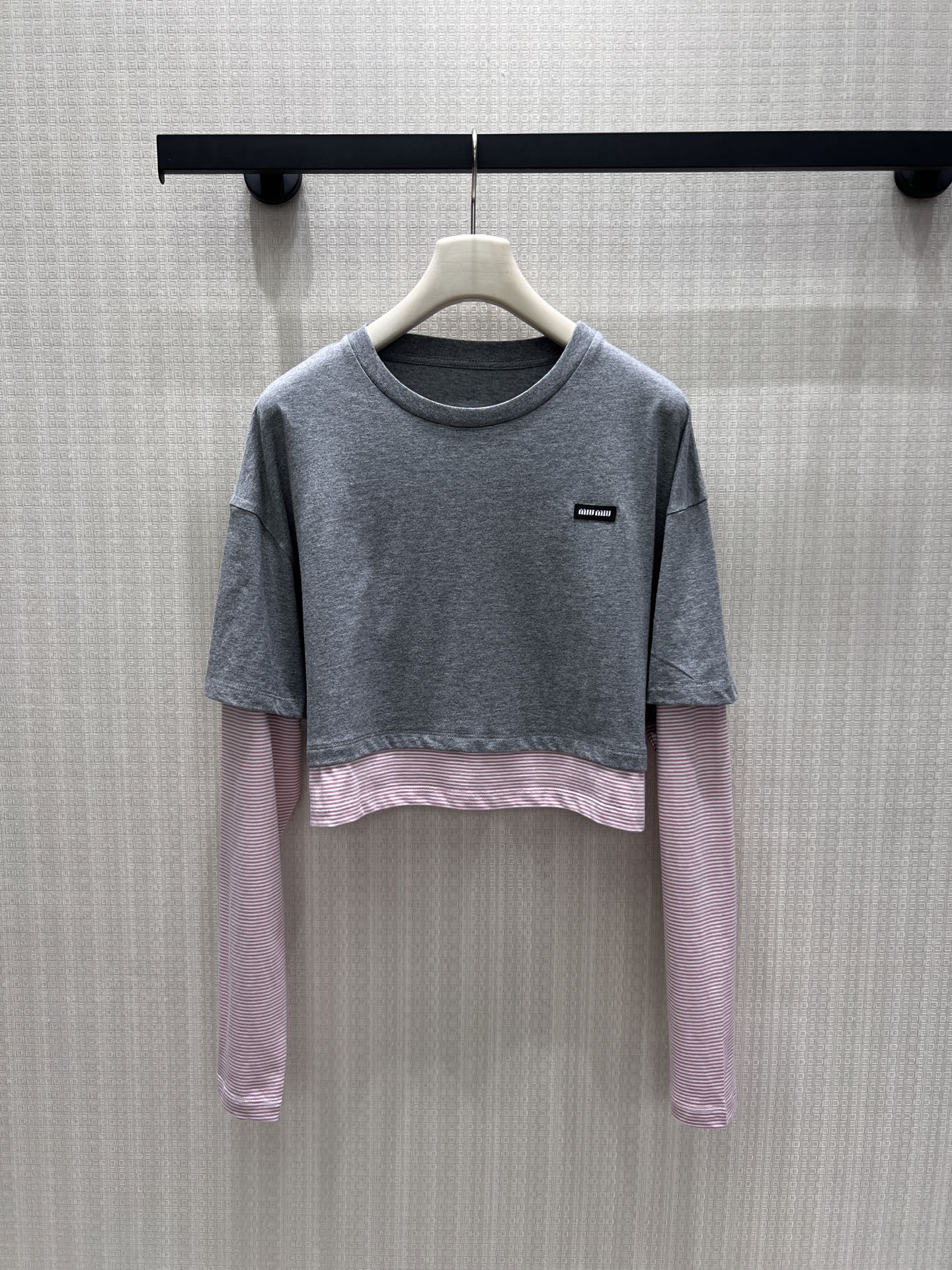 NO:911283,26 spring and summer new products  Miu** fake two-piece long sleeves, heather gray short sleeves layered with pink stripes as a base, the layers are relaxed and proportional. The soft round neck fits the neck, and the mini woven label on the chest low-key logo brand tone. Soft and skin-friendly cotton fabric, breathable and comfortable. Drop shoulder loose fit bag  It flatters the body shape, the short cut raises the waistline, and the sweet and cool contrasting colors bring a retro college atmosphere. It is great when worn alone and layered. It is gentle and age-reducing, showing the light and luxurious texture of a girl. Ready-made 36/38/40 real shot details, miumiu, T-shirt,1986090926春夏新品 Miu**假两件长袖,麻灰短款短袖叠搭粉条纹打底,层次松弛又显比例.柔和圆领贴合脖颈,胸前迷你织标低调标识品牌调性.软糯亲肤棉质面料,透气舒适.落肩宽松版型包容身形,短款剪裁拉高腰线,甜酷撞色自带复古学院氛围,单穿叠搭都很出彩,温柔减龄尽显少女轻奢质感.现货36/38/40实拍细节图,,miumiu,T-shirt,,Women's clothing