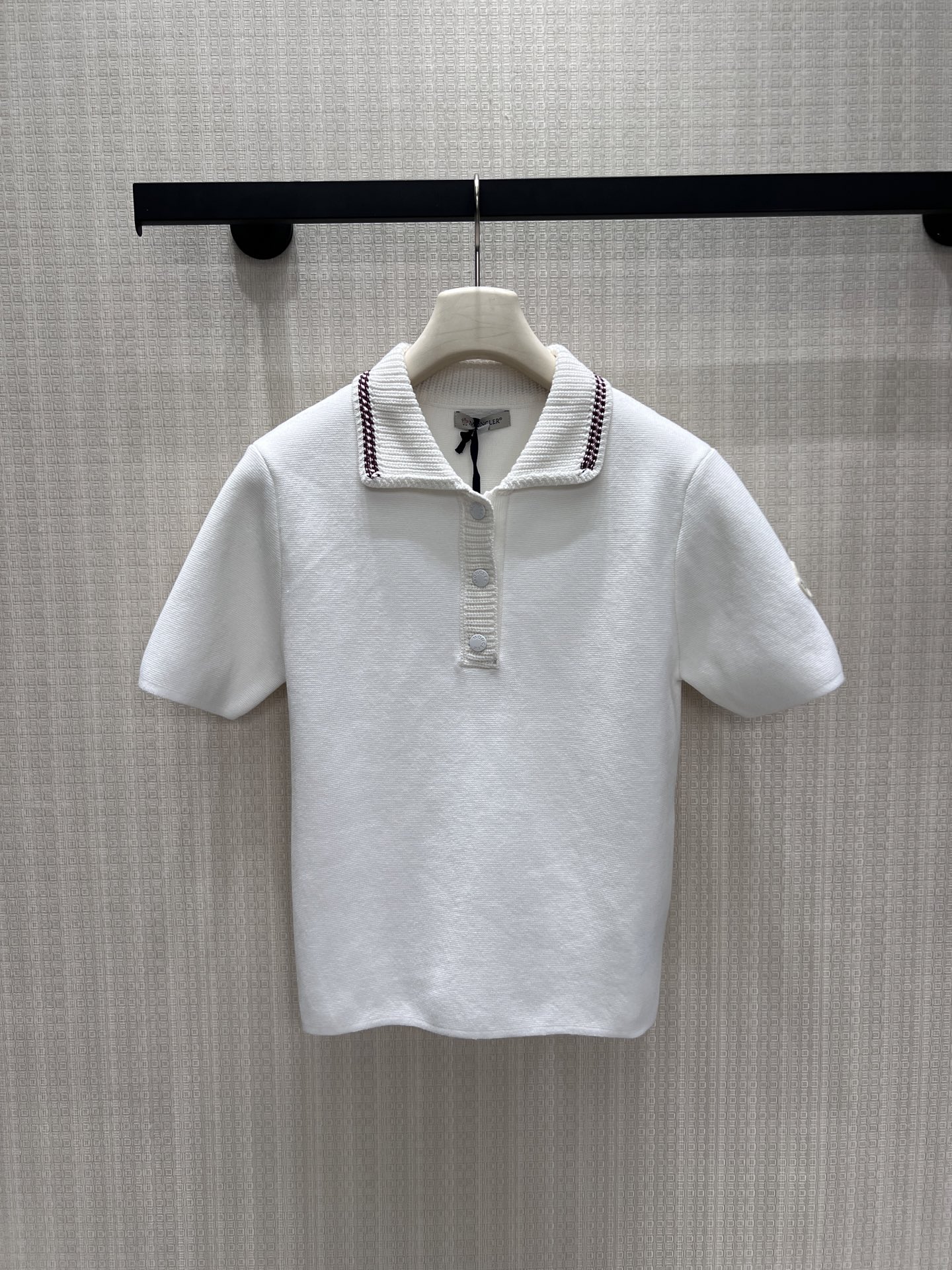 NO:912096,New product for spring and summer 26. Pure off-white knitted short-sleeved fabric. The fabric is soft and delicate. The crisp lapels are matched with contrasting webbing to outline exquisite layers. The half-breasted button design softly modifies the neck line. The low-key brand logo on the sleeve side hides recognition. The fitted short version raises the waistline. Simple retro college style, suitable for commuting and leisure. Wear it alone, refreshing and clean, and pair it with skirts and trousers to show a gentle, light and luxurious texture. Ready in stock smL  Actual detailed pictures, skirts, T-shirts,1986090926春夏新品 纯净米白针织短袖 面料软糯细腻,挺括翻领搭配撞色织带勾勒精致层次,半开襟排扣设计柔和修饰颈部线条.袖侧低调品牌标识暗藏辨识度,合身短款版型拉高腰线.简约复古学院气质,通勤休闲皆适配,单穿清爽干净,搭配半裙长裤尽显温柔轻奢质感.现货smL 实拍细节图,,skirts,T-shirt,,Women's clothing