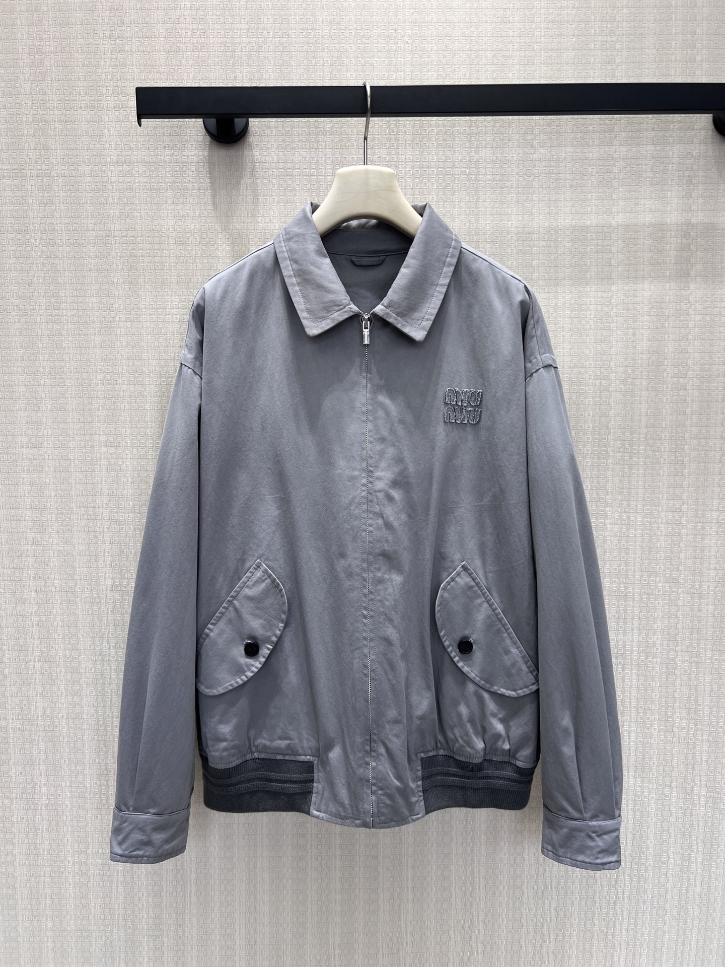 NO:926656,26 spring and summer new product Miu** light gray washed lapel jacket has a soft retro distressed texture, and the fabric feels relaxed and comfortable. The exquisite embroidery on the left chest implicitly presents the brand recognition, the curved button pocket is rich in layers, and the ribbed hem stabilizes the body shape. The dropped shoulder version is very tolerant to the body shape, and the low saturated gray tone is versatile and durable. It is suitable for all kinds of inner wear. It can be worn for daily shopping and light outings, easily interpreting the gentle retro, refined and low-key luxury style of girls.  In stock 36/38/40 real shot details,,miumiu,jackets & coats,1986090926春夏新品 Miu**浅灰色水洗翻领外套 自带柔和复古做旧肌理,面料触感松弛舒适.左胸精致刺绣含蓄呈现品牌辨识度,弧形纽扣口袋丰富层次,罗纹下摆稳固衣身版型.落肩版型对身形包容度出众,低饱和灰调百搭耐看,适配各式内搭,日常逛街、轻外出皆可穿搭,轻松演绎温柔复古、精致低调的少女轻奢穿搭风格 现货36/38/40 实拍细节图,,miumiu,jackets & coats,,Women's clothing