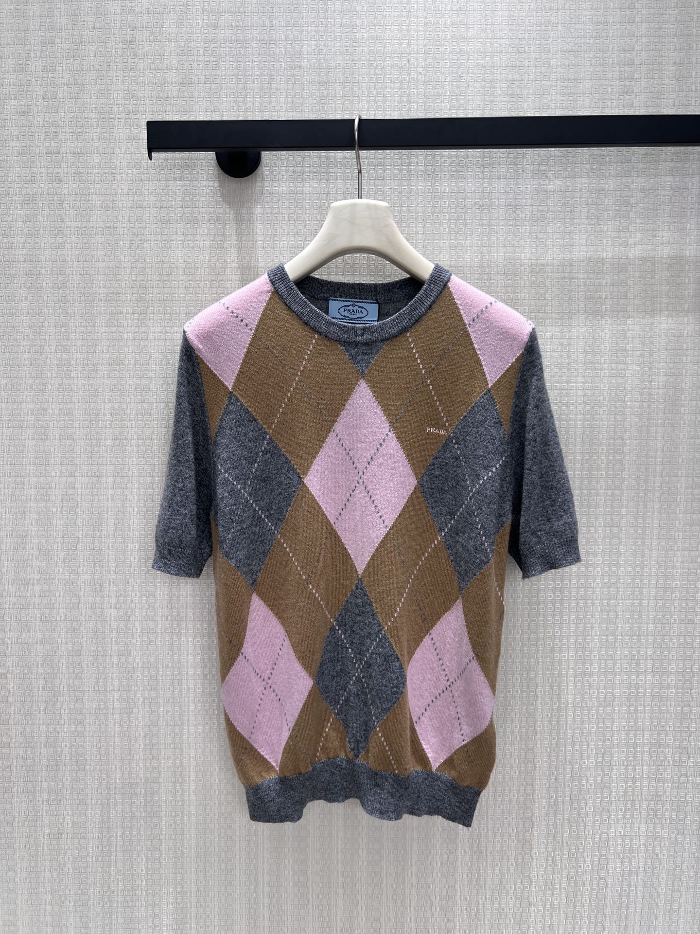 NO:935222,26th early autumn new product Pra** diamond short-sleeved wool sweater, the retro contrasting diamond pattern is gentle and soft, and the three colors of pink, brown and gray are intertwined to outline the retro college atmosphere. The fine wool knitting is soft and skin-friendly, the round neck version is simple and versatile, and the micro logo on the body is low-key and restrained. The three-quarter sleeves are refreshing and suitable for spring and autumn, and the fit is slightly loose to modify the body shape. It goes well with skirts and trousers, perfectly blending retro girls with the relaxed texture of old money. Ready in stock smL  Actual detailed pictures, prada,skirts,sweaters,T-shirt,1986090926早秋新品 Pra**菱格短袖羊毛毛衣,复古撞色菱格温柔柔和,粉棕灰三色交织勾勒学院复古氛围.细腻羊毛针织软糯亲肤,圆领版型简约百搭,衣身微型logo低调内敛.五分袖剪裁清爽适配春秋,合身微宽松版型修饰身形,搭配半裙、西裤皆出彩,把复古少女与老钱松弛质感完美融合.现货smL 实拍细节图,,prada,skirts,sweaters,T-shirt,,Women's clothing
