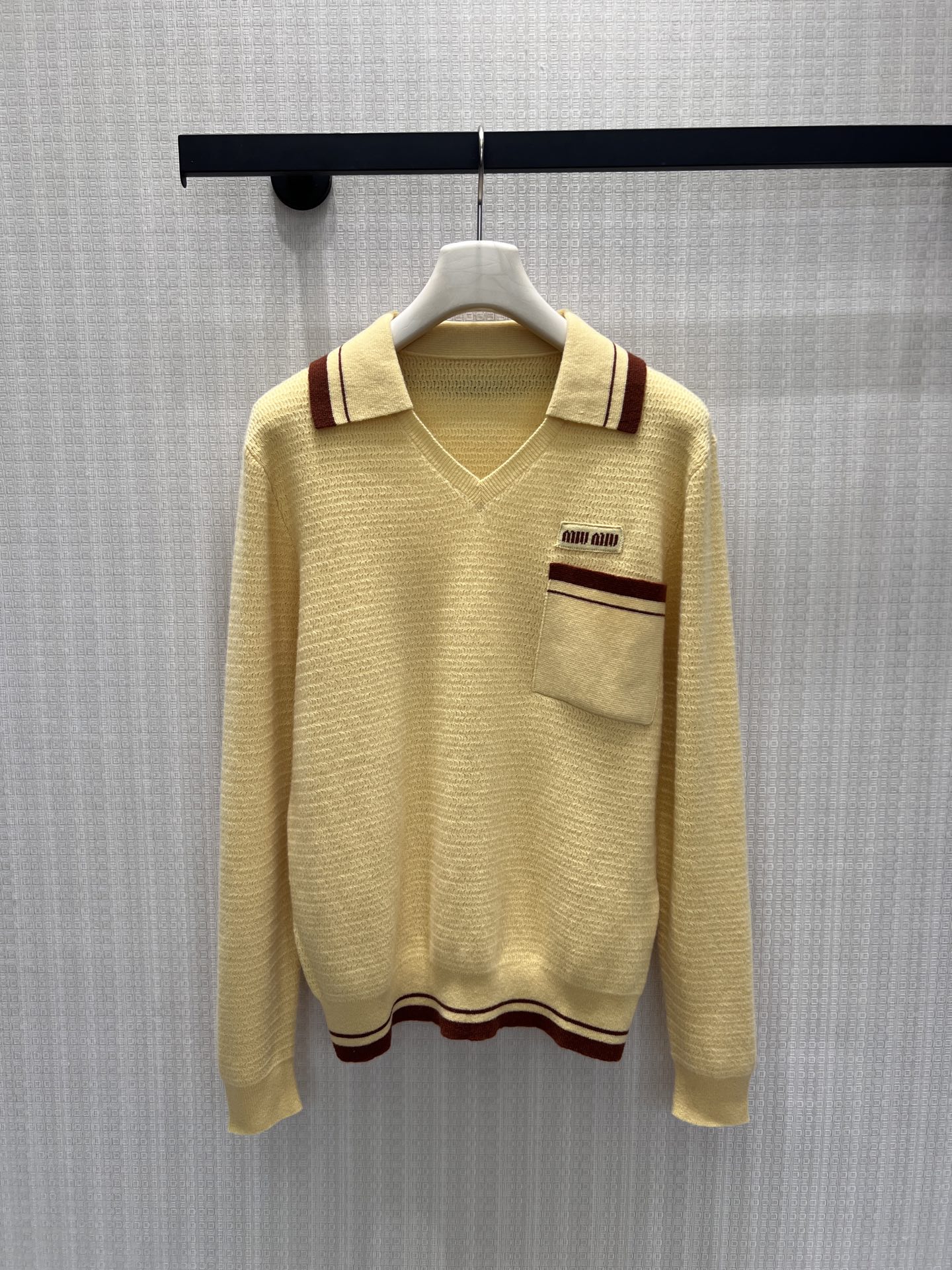 NO:950744,26 early autumn new style  The miu** sweater has a soft creamy yellow tone that is healing and refreshing. Contrast brown strips outline the lapels, pockets and hem, replicating the retro college aesthetic. The unique V-shaped Polo collar softens the neck line, and the chest patch pocket is equipped with a woven label. The details are full of ingenuity. The soft and waxy knitted texture is skin-friendly, breathable and fits well.  The shape is comfortable and slimming. It has a balance between girlishness and light luxury. It is suitable for matching with skirts and suits, and it is easy to create a warm and elegant retro outfit. Ready-made 36/38/40 real shot details, miumiu, skirts, sweaters, business  suit,1986090926早秋新款 miu**毛衣柔和奶黄色调治愈清新,撞色棕条勾勒翻领、口袋与下摆,复刻复古学院美学.别致V型Polo领柔和颈部线条,胸前贴袋搭配织唛标识,细节充满巧思.软糯针织肌理亲肤透气,合身版型自在显瘦.少女感与轻奢感平衡,搭配半裙、西装皆适配,轻松打造元气温婉的复古穿搭.现货36/38/40实拍细节图,,miumiu,skirts,sweaters,business suit,,Women's clothing