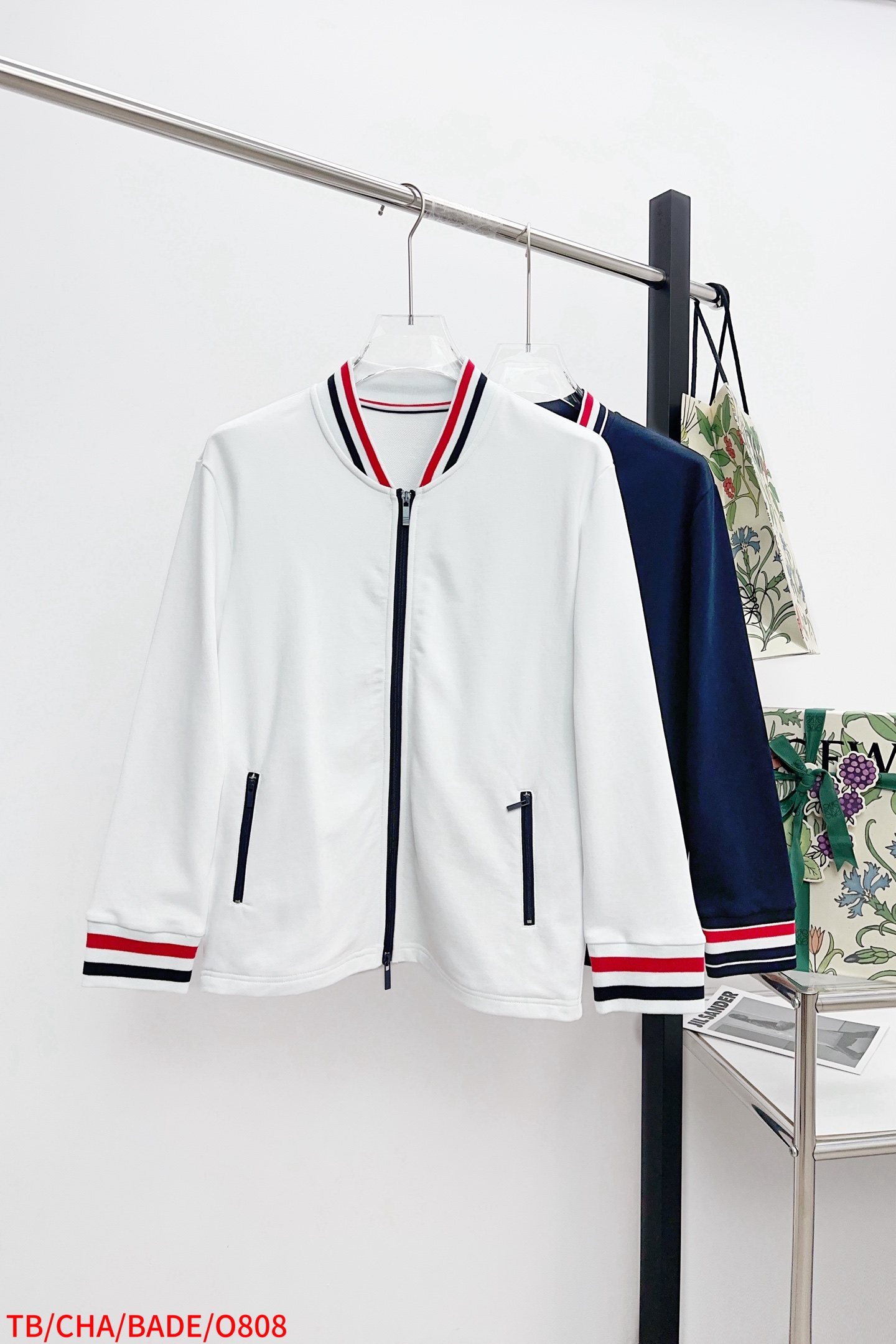 NO:596378,O808 TB THOM BROWNE leader red, white and blue ribbed zipper jacket. The red, white and blue woven details on the collar and cuffs, and the brand's iconic four stripes are cleverly integrated, which instantly enhances the overall fashion recognition. It is a unique trend when walking on the street. Moreover, it is made of pure cotton, which is soft and comfortable to wear, and has excellent breathability. There is no need to worry about sweating. Whether it is daily commuting or gathering with friends on weekends, it can be easily controlled.  The white model is clean and pure, while the navy blue model is calm and elegant. The design is the same for men and women. Whether you are buying new clothes for yourself or as a couple, it is an excellent choice. With this THOM BROWNE zipper jacket, you are the most fashionable person on the street. You have a good sense of fashion atmosphere. Get it now and don’t let fashion slip away!  Color white blue code number 1234 complete three standards, jackets & coats, alexander wang19860909O808 TB THOM BROWNE领袖红白蓝螺纹拉链夹克 领口与袖口处的红白蓝色织细节,品牌标志性的四道杠巧妙融入,瞬间提升整体的时尚辨识度,走在街上就是独树一帜的潮流存在. 而且它是纯棉材质,贴身穿柔软又舒适,透气性能一绝,完全不用担心会闷汗 ,不管是日常通勤,还是周末和朋友聚会,都能轻松驾驭. 白色款干净纯粹,藏蓝色款沉稳大气, 男女同款的设计,无论是给自己添置新衣,还是和另一半组个情侣穿搭,它都是绝佳之选. 拥有这件THOM BROWNE拉链夹克,你就是街头最会穿的时髦精,时尚氛围感狠狠拿捏,赶紧入手,别让时尚溜走啦！ 颜色白色 蓝色 码数1234 三标齐全,,jackets & coats,alexander wang,Men's clothing