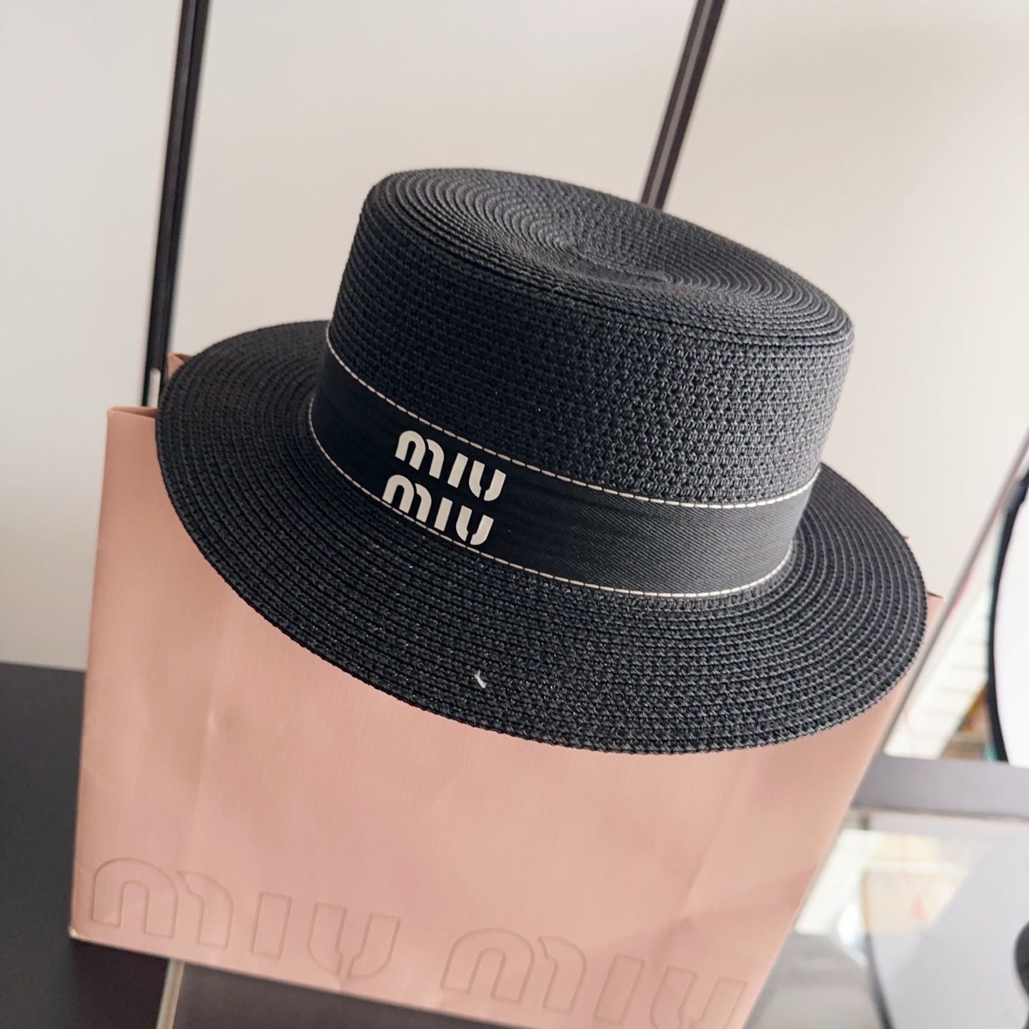 Черная шляпа из плетеного материала с надписью miu miu