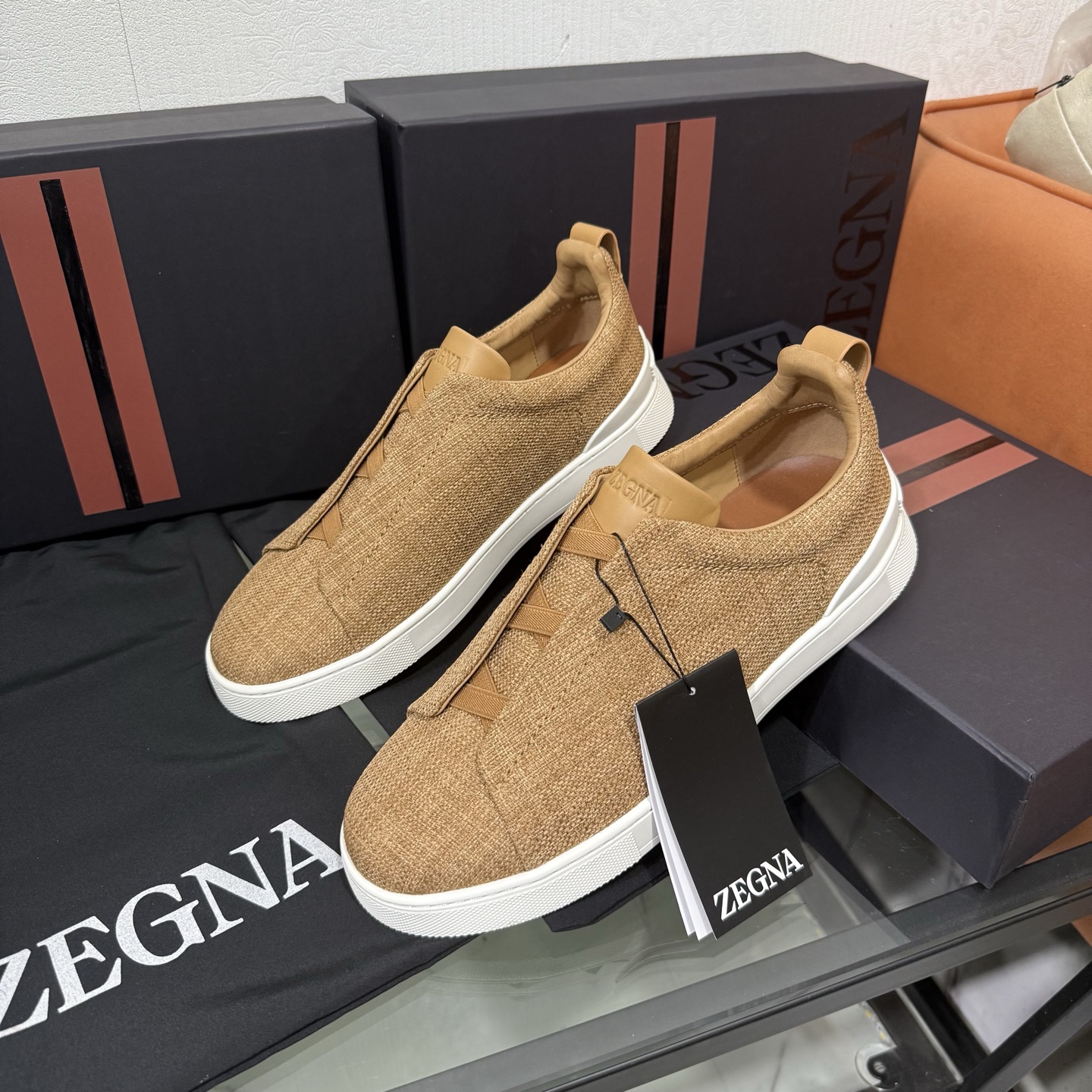 Zegna/杰尼亚 SECONDSKIN Triple Stitch&trade; 休闲运动鞋，帆布系列
这款低帮运动鞋的鞋面光滑柔软。饰以标志性三重交叉松紧细节，致敬品牌精裁夹克的手工缝制工艺。设计轻盈，与白色橡胶鞋底相得益彰，专为快节奏的生活方式打造。这款鞋汲取手套制作灵感，融汇世代工匠经验智慧，选用新西兰顶级小牛皮制作，成就轻盈质地，精致衬里结合非凡韧性。带来独一无二的贴合感。非常轻盈的橡胶外底上点缀双条纹 Logo 运动细节，以超轻结构重新诠释标志性鞋款。领口部位鹿皮面料反车做法，无内裡车中底套楦做法。易穿脱套脚交叉松紧带和 3D&ldquo;波纹&rdquo;设计。鞋舌热压品牌名称。
后跟加贴 TPU 双条纹品牌 Logo 饰条，鞋身空胶做法，周圈加车大底缝线。轻盈的高弹力橡胶外底背面和可拆卸脚床饰 Zegna 标识，为这款运动鞋增添现代动感气息。
皮鞋码数:39/40/41/42/43/44/45/46/47 
专柜包装，现货