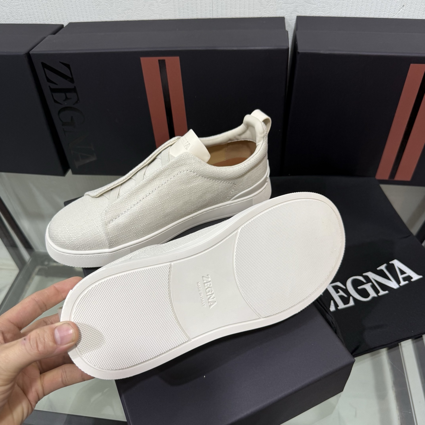 Zegna/杰尼亚 SECONDSKIN Triple Stitch&trade; 休闲运动鞋，帆布系列
这款低帮运动鞋的鞋面光滑柔软。饰以标志性三重交叉松紧细节，致敬品牌精裁夹克的手工缝制工艺。设计轻盈，与白色橡胶鞋底相得益彰，专为快节奏的生活方式打造。这款鞋汲取手套制作灵感，融汇世代工匠经验智慧，选用新西兰顶级小牛皮制作，成就轻盈质地，精致衬里结合非凡韧性。带来独一无二的贴合感。非常轻盈的橡胶外底上点缀双条纹 Logo 运动细节，以超轻结构重新诠释标志性鞋款。领口部位鹿皮面料反车做法，无内裡车中底套楦做法。易穿脱套脚交叉松紧带和 3D&ldquo;波纹&rdquo;设计。鞋舌热压品牌名称。
后跟加贴 TPU 双条纹品牌 Logo 饰条，鞋身空胶做法，周圈加车大底缝线。轻盈的高弹力橡胶外底背面和可拆卸脚床饰 Zegna 标识，为这款运动鞋增添现代动感气息。
皮鞋码数:39/40/41/42/43/44/45/46/47 
专柜包装，现货