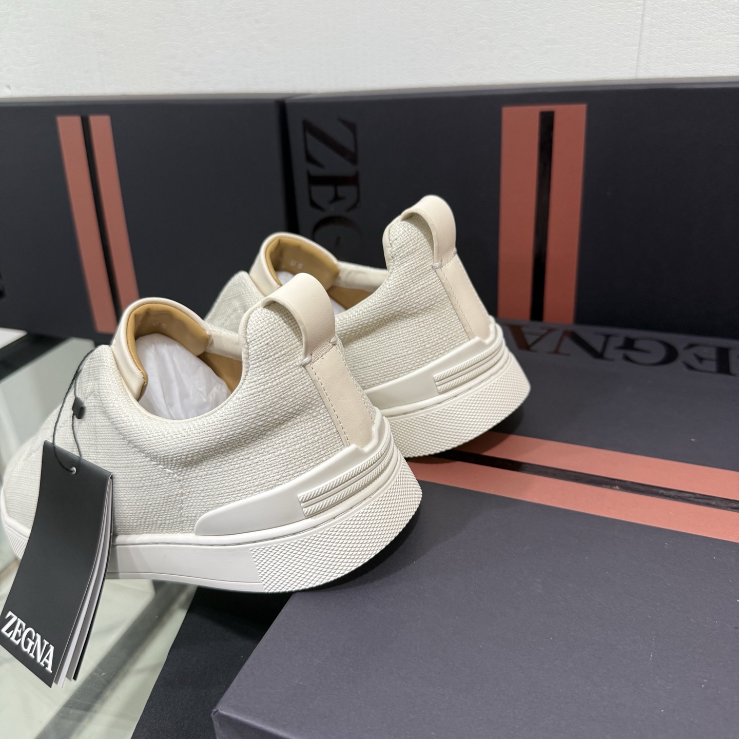 Zegna/杰尼亚 SECONDSKIN Triple Stitch&trade; 休闲运动鞋，帆布系列
这款低帮运动鞋的鞋面光滑柔软。饰以标志性三重交叉松紧细节，致敬品牌精裁夹克的手工缝制工艺。设计轻盈，与白色橡胶鞋底相得益彰，专为快节奏的生活方式打造。这款鞋汲取手套制作灵感，融汇世代工匠经验智慧，选用新西兰顶级小牛皮制作，成就轻盈质地，精致衬里结合非凡韧性。带来独一无二的贴合感。非常轻盈的橡胶外底上点缀双条纹 Logo 运动细节，以超轻结构重新诠释标志性鞋款。领口部位鹿皮面料反车做法，无内裡车中底套楦做法。易穿脱套脚交叉松紧带和 3D&ldquo;波纹&rdquo;设计。鞋舌热压品牌名称。
后跟加贴 TPU 双条纹品牌 Logo 饰条，鞋身空胶做法，周圈加车大底缝线。轻盈的高弹力橡胶外底背面和可拆卸脚床饰 Zegna 标识，为这款运动鞋增添现代动感气息。
皮鞋码数:39/40/41/42/43/44/45/46/47 
专柜包装，现货