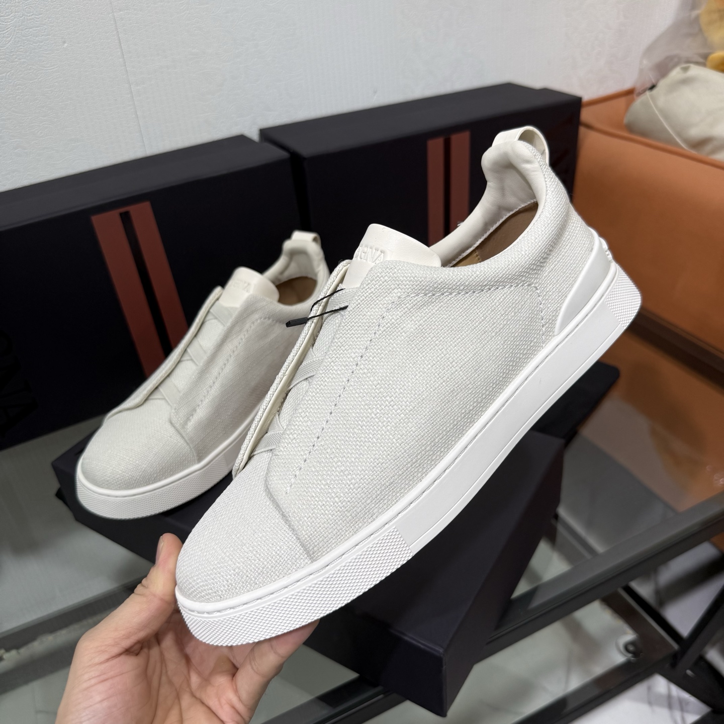 Zegna/杰尼亚 SECONDSKIN Triple Stitch&trade; 休闲运动鞋，帆布系列
这款低帮运动鞋的鞋面光滑柔软。饰以标志性三重交叉松紧细节，致敬品牌精裁夹克的手工缝制工艺。设计轻盈，与白色橡胶鞋底相得益彰，专为快节奏的生活方式打造。这款鞋汲取手套制作灵感，融汇世代工匠经验智慧，选用新西兰顶级小牛皮制作，成就轻盈质地，精致衬里结合非凡韧性。带来独一无二的贴合感。非常轻盈的橡胶外底上点缀双条纹 Logo 运动细节，以超轻结构重新诠释标志性鞋款。领口部位鹿皮面料反车做法，无内裡车中底套楦做法。易穿脱套脚交叉松紧带和 3D&ldquo;波纹&rdquo;设计。鞋舌热压品牌名称。
后跟加贴 TPU 双条纹品牌 Logo 饰条，鞋身空胶做法，周圈加车大底缝线。轻盈的高弹力橡胶外底背面和可拆卸脚床饰 Zegna 标识，为这款运动鞋增添现代动感气息。
皮鞋码数:39/40/41/42/43/44/45/46/47 
专柜包装，现货