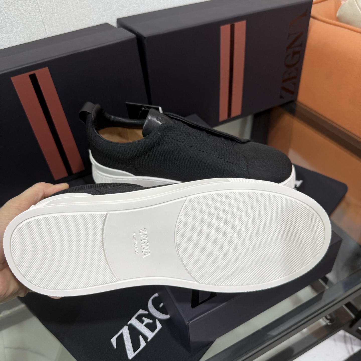 Zegna/杰尼亚 SECONDSKIN Triple Stitch&trade; 休闲运动鞋，帆布系列
这款低帮运动鞋的鞋面光滑柔软。饰以标志性三重交叉松紧细节，致敬品牌精裁夹克的手工缝制工艺。设计轻盈，与白色橡胶鞋底相得益彰，专为快节奏的生活方式打造。这款鞋汲取手套制作灵感，融汇世代工匠经验智慧，选用新西兰顶级小牛皮制作，成就轻盈质地，精致衬里结合非凡韧性。带来独一无二的贴合感。非常轻盈的橡胶外底上点缀双条纹 Logo 运动细节，以超轻结构重新诠释标志性鞋款。领口部位鹿皮面料反车做法，无内裡车中底套楦做法。易穿脱套脚交叉松紧带和 3D&ldquo;波纹&rdquo;设计。鞋舌热压品牌名称。
后跟加贴 TPU 双条纹品牌 Logo 饰条，鞋身空胶做法，周圈加车大底缝线。轻盈的高弹力橡胶外底背面和可拆卸脚床饰 Zegna 标识，为这款运动鞋增添现代动感气息。
皮鞋码数:39/40/41/42/43/44/45/46/47 ，48
专柜包装，现货