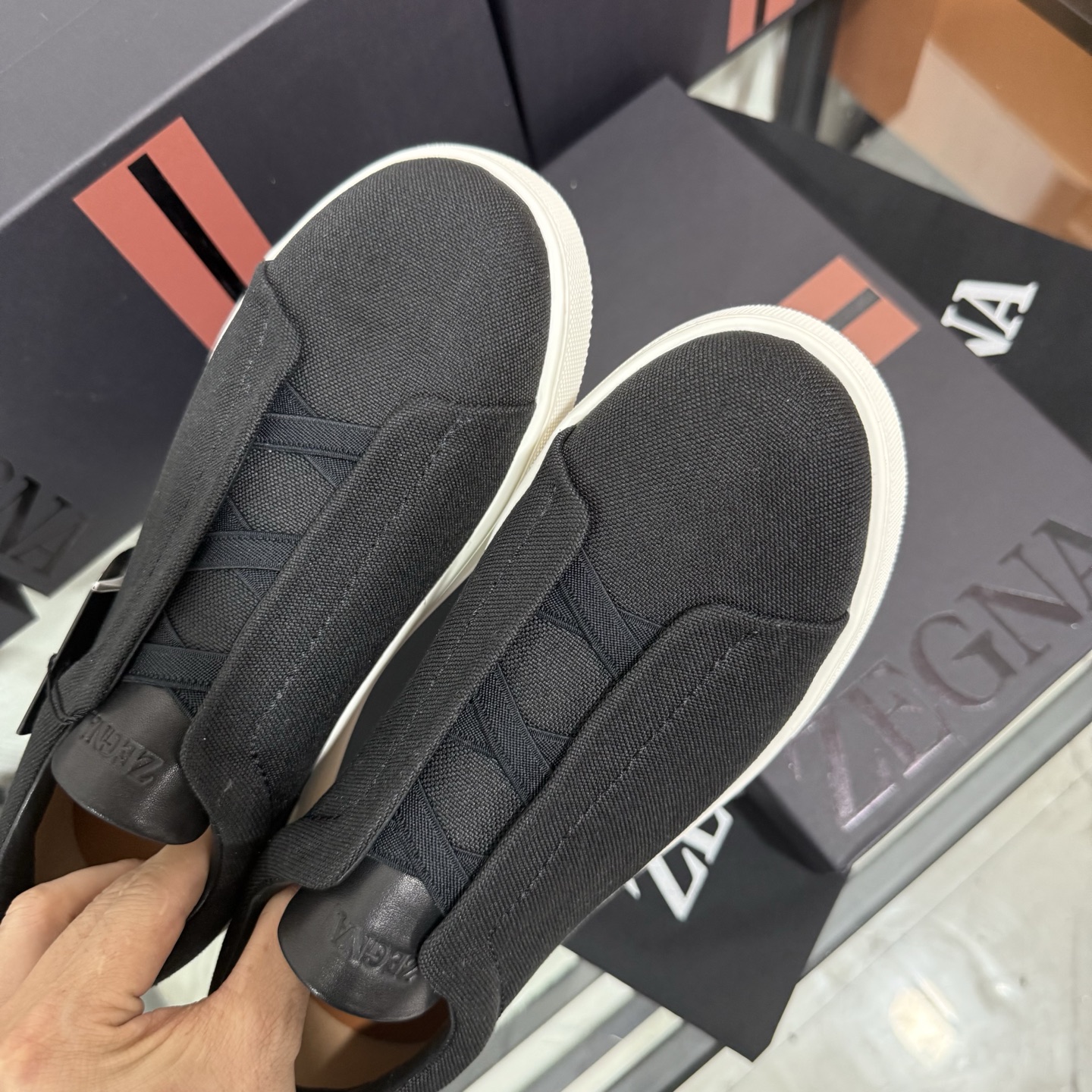 Zegna/杰尼亚 SECONDSKIN Triple Stitch&trade; 休闲运动鞋，帆布系列
这款低帮运动鞋的鞋面光滑柔软。饰以标志性三重交叉松紧细节，致敬品牌精裁夹克的手工缝制工艺。设计轻盈，与白色橡胶鞋底相得益彰，专为快节奏的生活方式打造。这款鞋汲取手套制作灵感，融汇世代工匠经验智慧，选用新西兰顶级小牛皮制作，成就轻盈质地，精致衬里结合非凡韧性。带来独一无二的贴合感。非常轻盈的橡胶外底上点缀双条纹 Logo 运动细节，以超轻结构重新诠释标志性鞋款。领口部位鹿皮面料反车做法，无内裡车中底套楦做法。易穿脱套脚交叉松紧带和 3D&ldquo;波纹&rdquo;设计。鞋舌热压品牌名称。
后跟加贴 TPU 双条纹品牌 Logo 饰条，鞋身空胶做法，周圈加车大底缝线。轻盈的高弹力橡胶外底背面和可拆卸脚床饰 Zegna 标识，为这款运动鞋增添现代动感气息。
皮鞋码数:39/40/41/42/43/44/45/46/47 ，48
专柜包装，现货