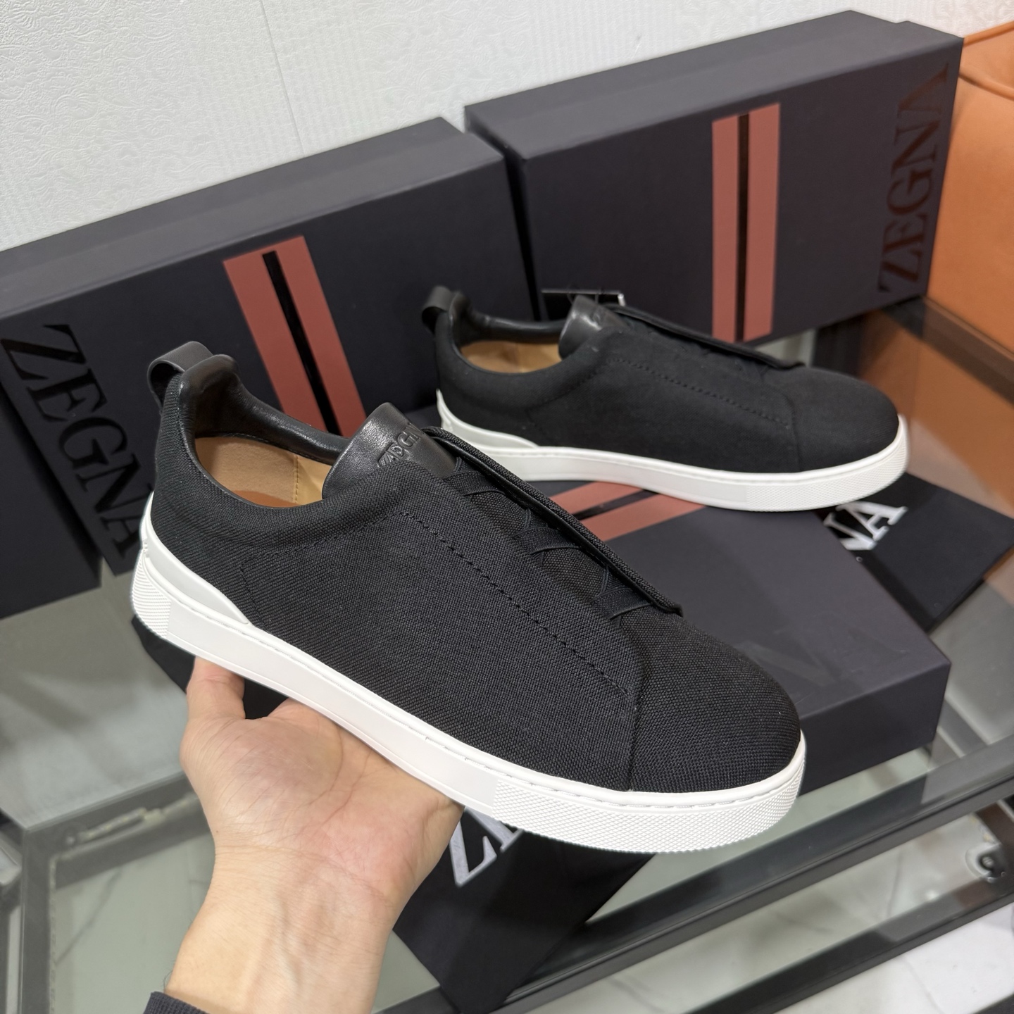 Zegna/杰尼亚 SECONDSKIN Triple Stitch&trade; 休闲运动鞋，帆布系列
这款低帮运动鞋的鞋面光滑柔软。饰以标志性三重交叉松紧细节，致敬品牌精裁夹克的手工缝制工艺。设计轻盈，与白色橡胶鞋底相得益彰，专为快节奏的生活方式打造。这款鞋汲取手套制作灵感，融汇世代工匠经验智慧，选用新西兰顶级小牛皮制作，成就轻盈质地，精致衬里结合非凡韧性。带来独一无二的贴合感。非常轻盈的橡胶外底上点缀双条纹 Logo 运动细节，以超轻结构重新诠释标志性鞋款。领口部位鹿皮面料反车做法，无内裡车中底套楦做法。易穿脱套脚交叉松紧带和 3D&ldquo;波纹&rdquo;设计。鞋舌热压品牌名称。
后跟加贴 TPU 双条纹品牌 Logo 饰条，鞋身空胶做法，周圈加车大底缝线。轻盈的高弹力橡胶外底背面和可拆卸脚床饰 Zegna 标识，为这款运动鞋增添现代动感气息。
皮鞋码数:39/40/41/42/43/44/45/46/47 ，48
专柜包装，现货