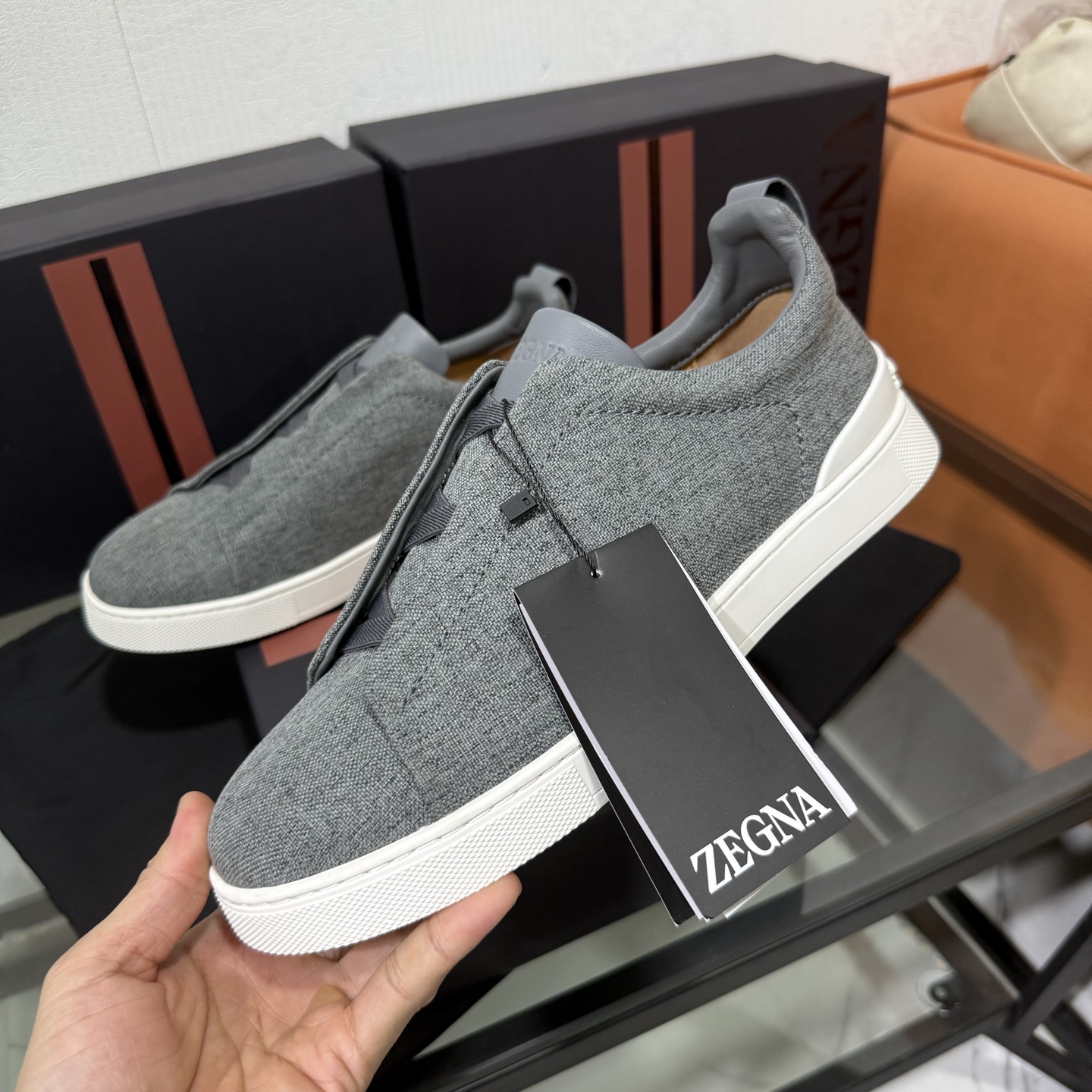 Zegna/杰尼亚 SECONDSKIN Triple Stitch&trade; 休闲运动鞋，帆布系列
这款低帮运动鞋的鞋面光滑柔软。饰以标志性三重交叉松紧细节，致敬品牌精裁夹克的手工缝制工艺。设计轻盈，与白色橡胶鞋底相得益彰，专为快节奏的生活方式打造。这款鞋汲取手套制作灵感，融汇世代工匠经验智慧，选用新西兰顶级小牛皮制作，成就轻盈质地，精致衬里结合非凡韧性。带来独一无二的贴合感。非常轻盈的橡胶外底上点缀双条纹 Logo 运动细节，以超轻结构重新诠释标志性鞋款。领口部位鹿皮面料反车做法，无内裡车中底套楦做法。易穿脱套脚交叉松紧带和 3D&ldquo;波纹&rdquo;设计。鞋舌热压品牌名称。
后跟加贴 TPU 双条纹品牌 Logo 饰条，鞋身空胶做法，周圈加车大底缝线。轻盈的高弹力橡胶外底背面和可拆卸脚床饰 Zegna 标识，为这款运动鞋增添现代动感气息。
皮鞋码数:39/40/41/42/43/44/45/46/47 
专柜包装，现货