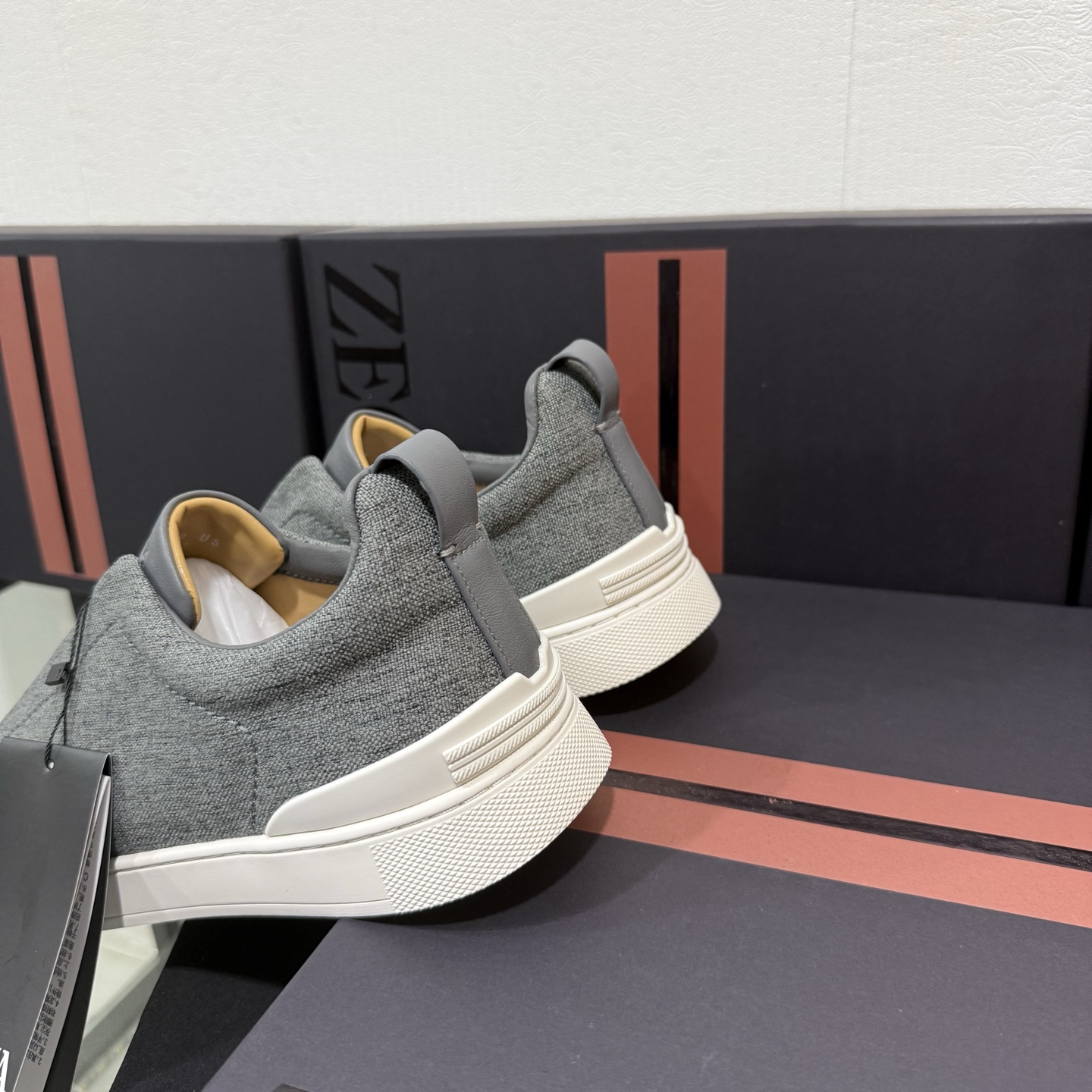 Zegna/杰尼亚 SECONDSKIN Triple Stitch&trade; 休闲运动鞋，帆布系列
这款低帮运动鞋的鞋面光滑柔软。饰以标志性三重交叉松紧细节，致敬品牌精裁夹克的手工缝制工艺。设计轻盈，与白色橡胶鞋底相得益彰，专为快节奏的生活方式打造。这款鞋汲取手套制作灵感，融汇世代工匠经验智慧，选用新西兰顶级小牛皮制作，成就轻盈质地，精致衬里结合非凡韧性。带来独一无二的贴合感。非常轻盈的橡胶外底上点缀双条纹 Logo 运动细节，以超轻结构重新诠释标志性鞋款。领口部位鹿皮面料反车做法，无内裡车中底套楦做法。易穿脱套脚交叉松紧带和 3D&ldquo;波纹&rdquo;设计。鞋舌热压品牌名称。
后跟加贴 TPU 双条纹品牌 Logo 饰条，鞋身空胶做法，周圈加车大底缝线。轻盈的高弹力橡胶外底背面和可拆卸脚床饰 Zegna 标识，为这款运动鞋增添现代动感气息。
皮鞋码数:39/40/41/42/43/44/45/46/47 
专柜包装，现货