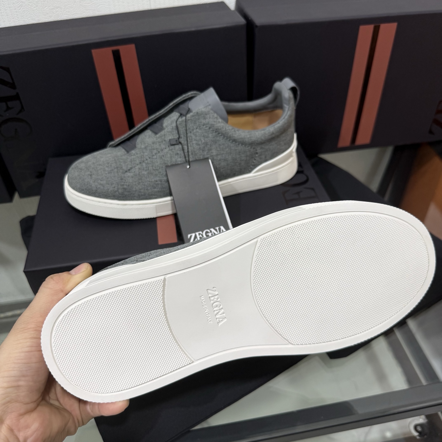Zegna/杰尼亚 SECONDSKIN Triple Stitch&trade; 休闲运动鞋，帆布系列
这款低帮运动鞋的鞋面光滑柔软。饰以标志性三重交叉松紧细节，致敬品牌精裁夹克的手工缝制工艺。设计轻盈，与白色橡胶鞋底相得益彰，专为快节奏的生活方式打造。这款鞋汲取手套制作灵感，融汇世代工匠经验智慧，选用新西兰顶级小牛皮制作，成就轻盈质地，精致衬里结合非凡韧性。带来独一无二的贴合感。非常轻盈的橡胶外底上点缀双条纹 Logo 运动细节，以超轻结构重新诠释标志性鞋款。领口部位鹿皮面料反车做法，无内裡车中底套楦做法。易穿脱套脚交叉松紧带和 3D&ldquo;波纹&rdquo;设计。鞋舌热压品牌名称。
后跟加贴 TPU 双条纹品牌 Logo 饰条，鞋身空胶做法，周圈加车大底缝线。轻盈的高弹力橡胶外底背面和可拆卸脚床饰 Zegna 标识，为这款运动鞋增添现代动感气息。
皮鞋码数:39/40/41/42/43/44/45/46/47 
专柜包装，现货