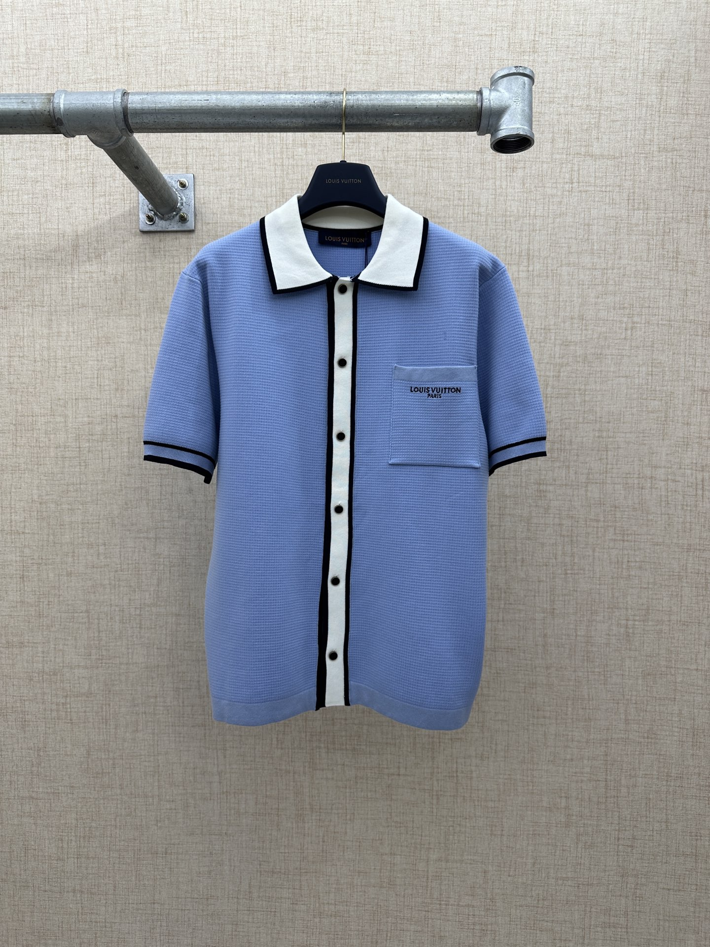 LV/路易威登 翻领短袖纽扣开合衬衫 2026 FW 夏季新款男士翻领短袖针织开襟衬天蓝色主体，黑色撞色包边，华夫格/坑条针织纹理，撞色嵌边工艺，版型宽松落肩廓形，纽扣定制金属纽扣，正面刻有LV品牌字母与经典标识，细节精致， 面料主料90…