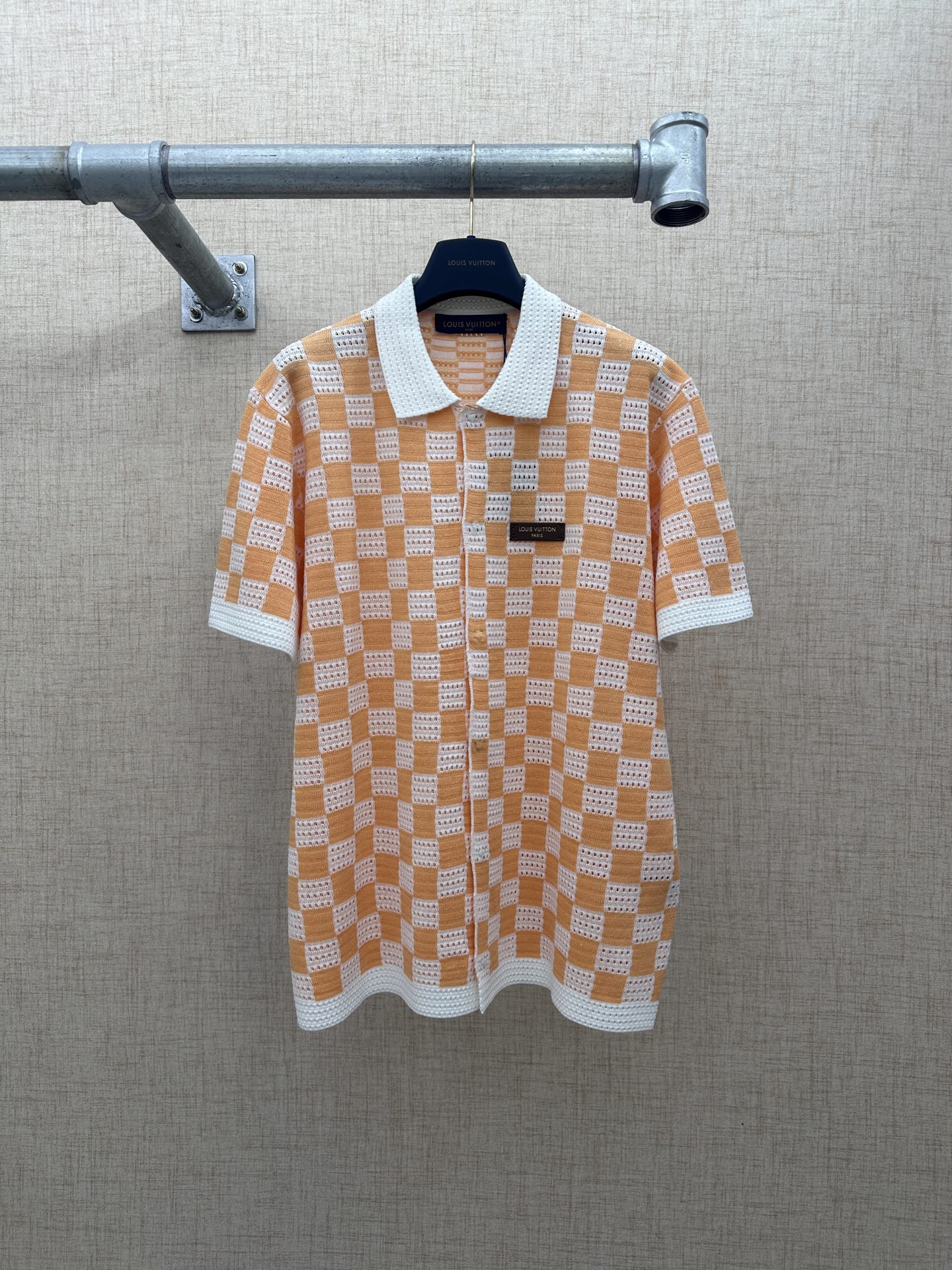 LV/Louis Vuitton 橙白棋盘格镂空开衫 LOUIS VUITTON Pharrell Williams 创意总监发表2026早秋新款 以经典的Damier棋盘格为灵感，采用橙白双色镂空针织工艺打造，方格内的网眼孔洞设计兼顾了…